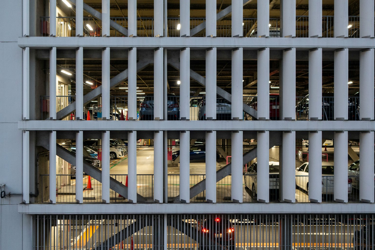 Immagine di una struttura di parcheggio con fessure verticali e auto visibili