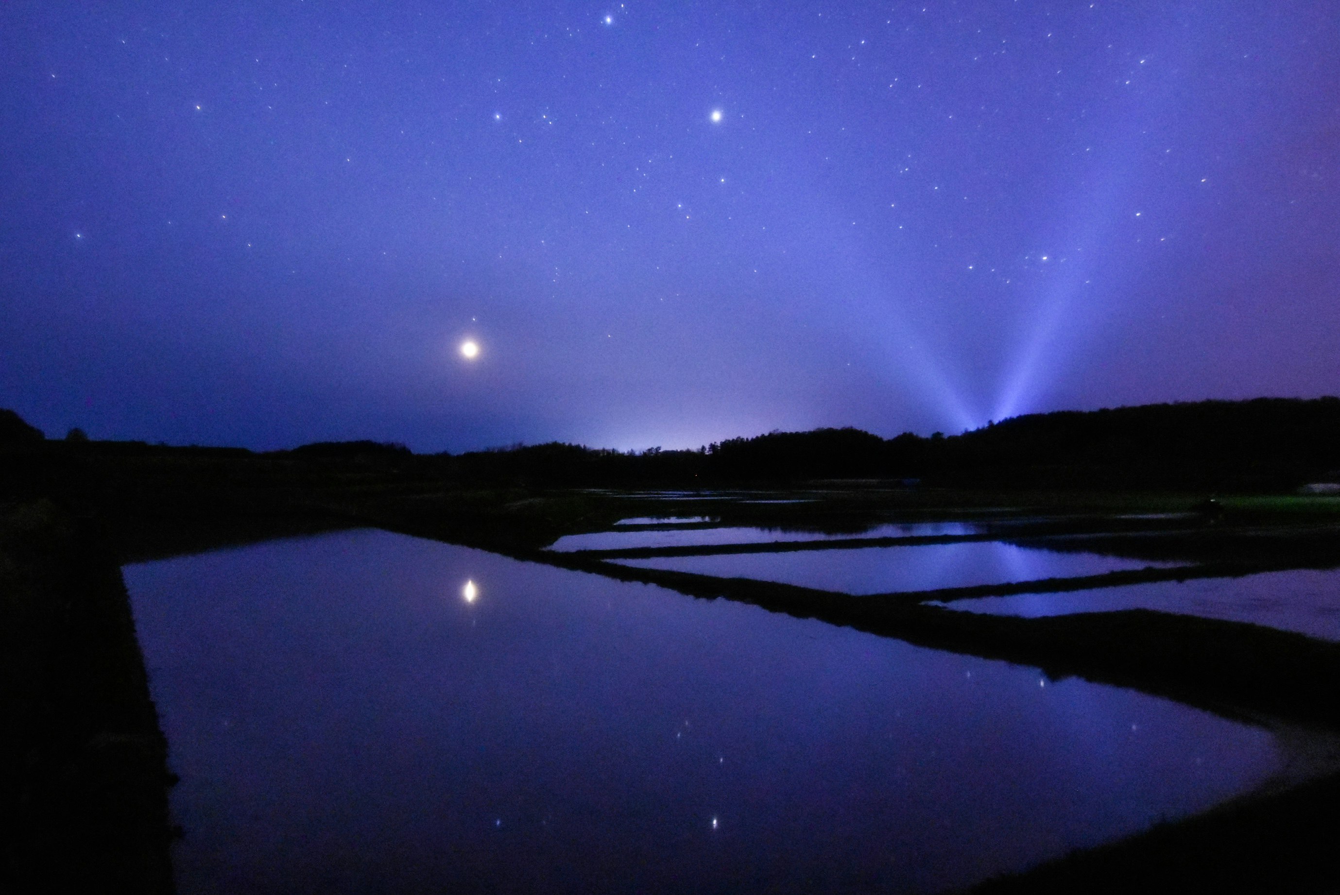 夜の川面に広がる星空と光の筋