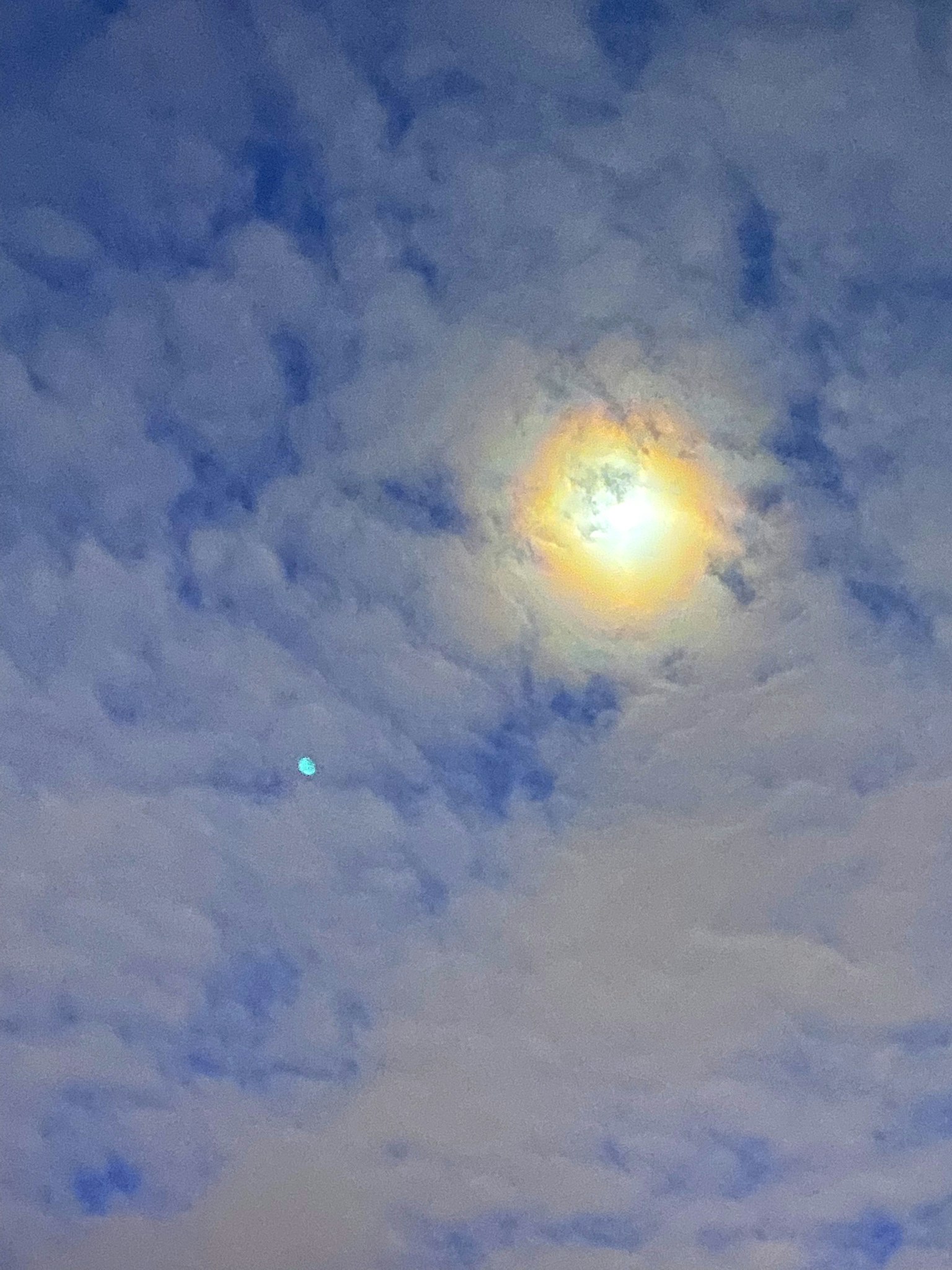 Bright sun surrounded by clouds in a blue sky