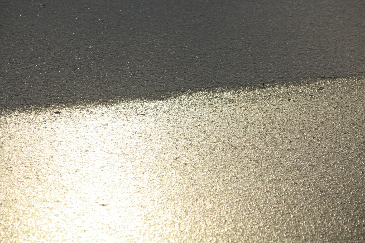 Image of a shiny gold surface intersecting with a dark background