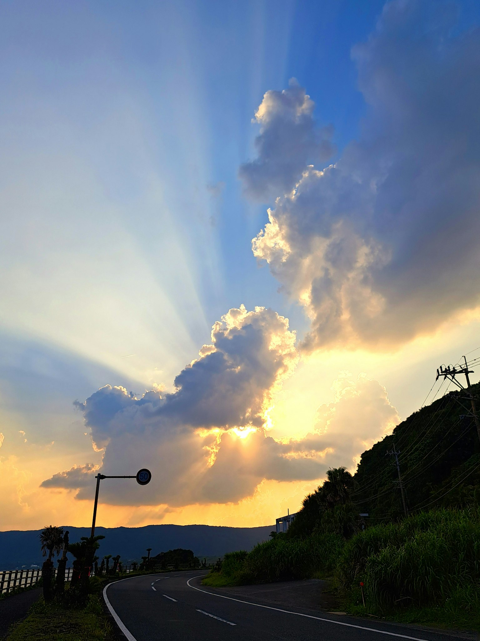 Schöne Landschaft mit Wolken und Lichtstrahlen im blauen Himmel