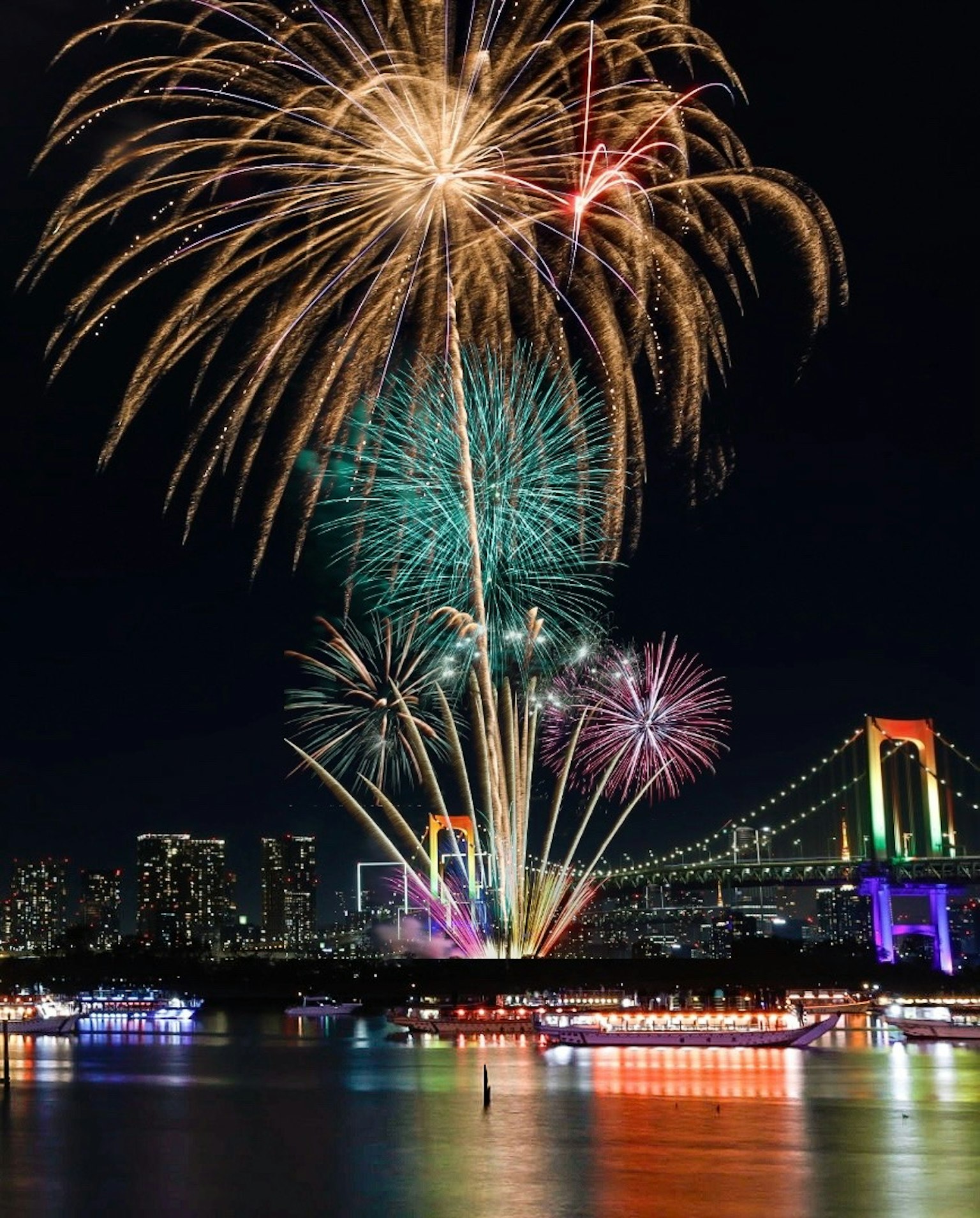 Colorful fireworks display over Tokyo Bay with Rainbow Bridge in the background