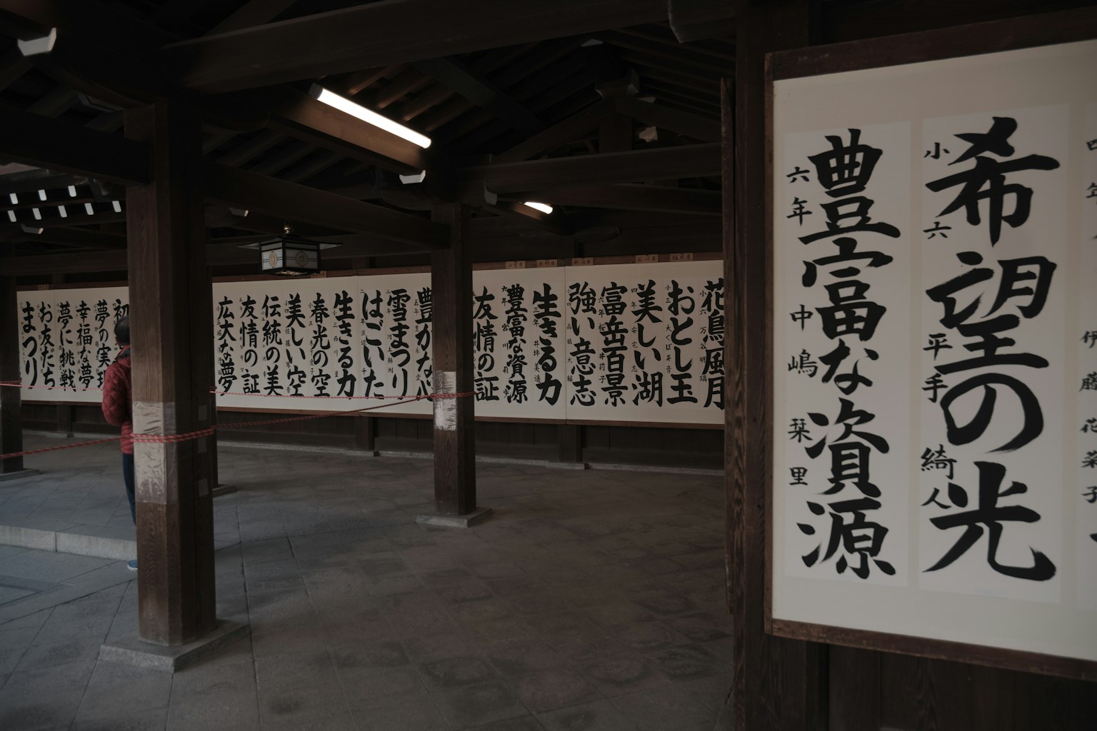 Testo calligrafico giapponese esposto su pannelli di legno in un ambiente tradizionale