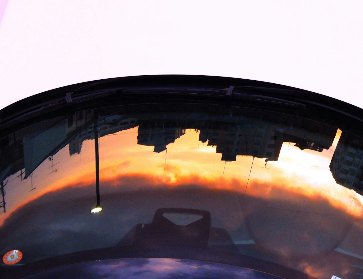 Vetro circolare che riflette un tramonto con skyline cittadino