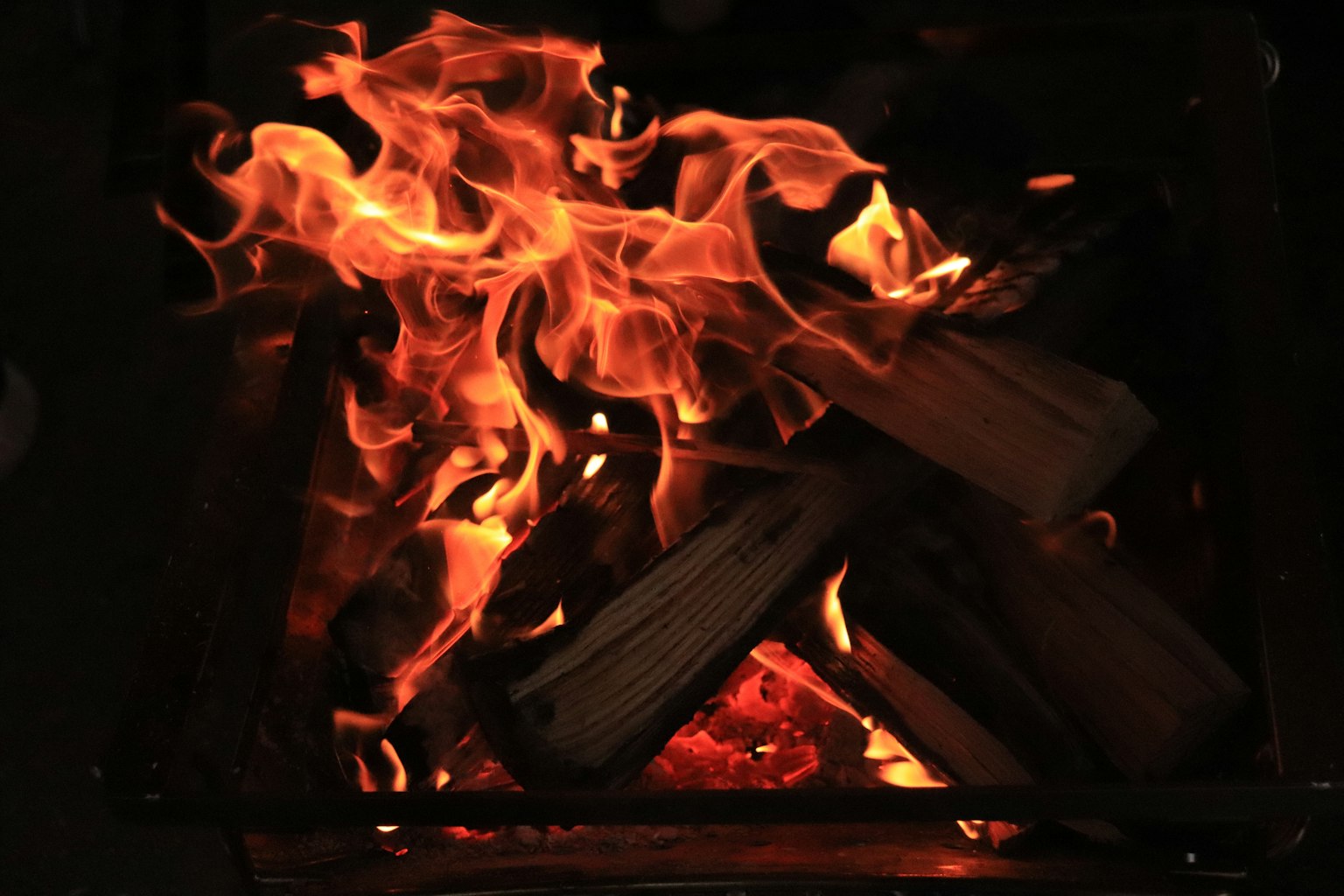 Fiamme che ballano in un camino con legna