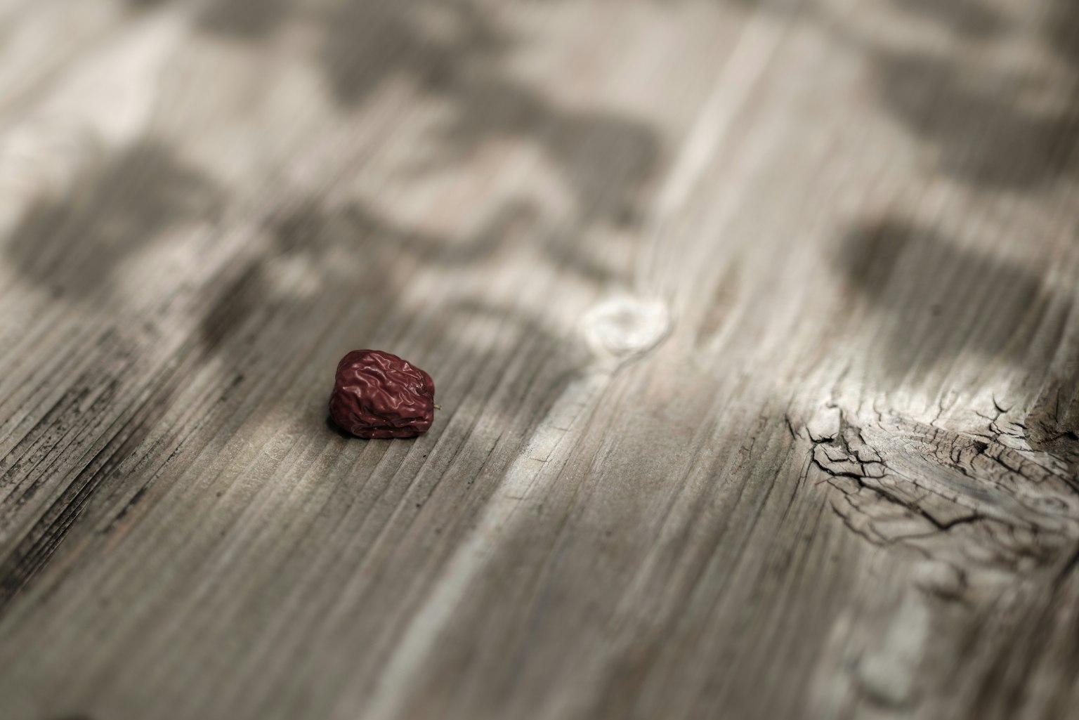 Una pequeña piedra roja sobre una mesa de madera