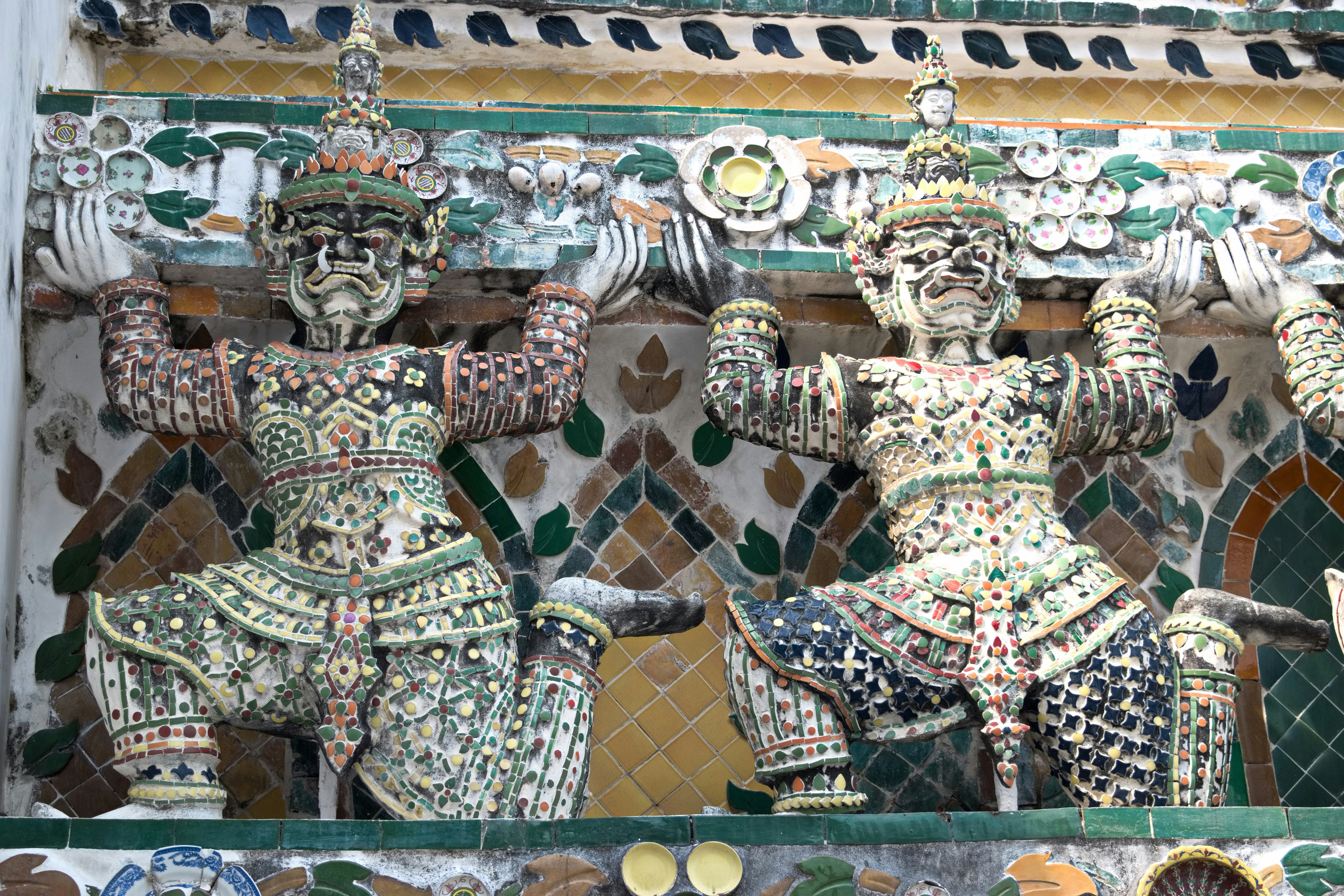 Ukiran dinding bergaya Thailand yang rumit dengan detail berlapis emas di fasad kuil