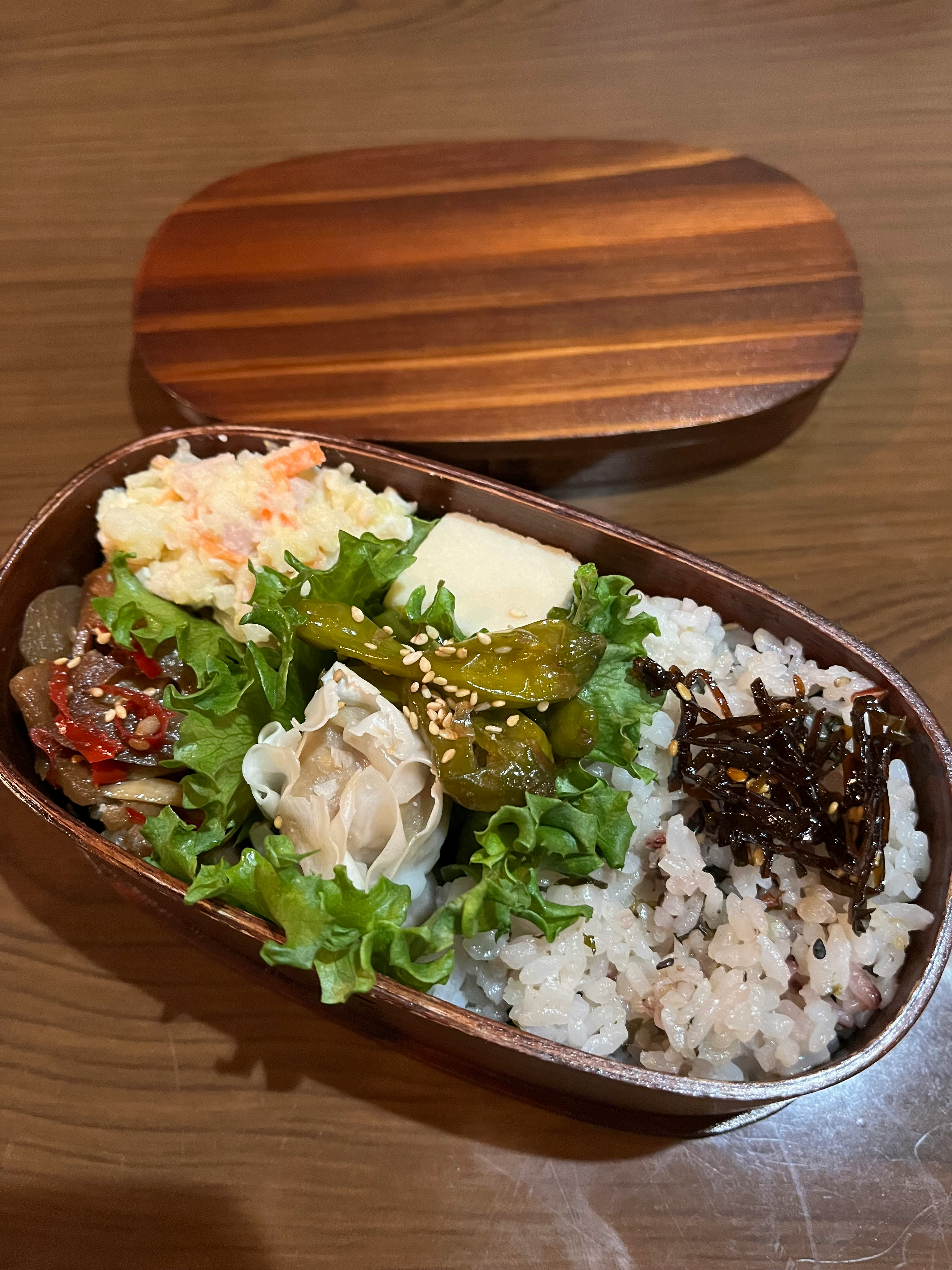 bekal bento dalam kotak kayu melengkung berisi nasi dan lauk