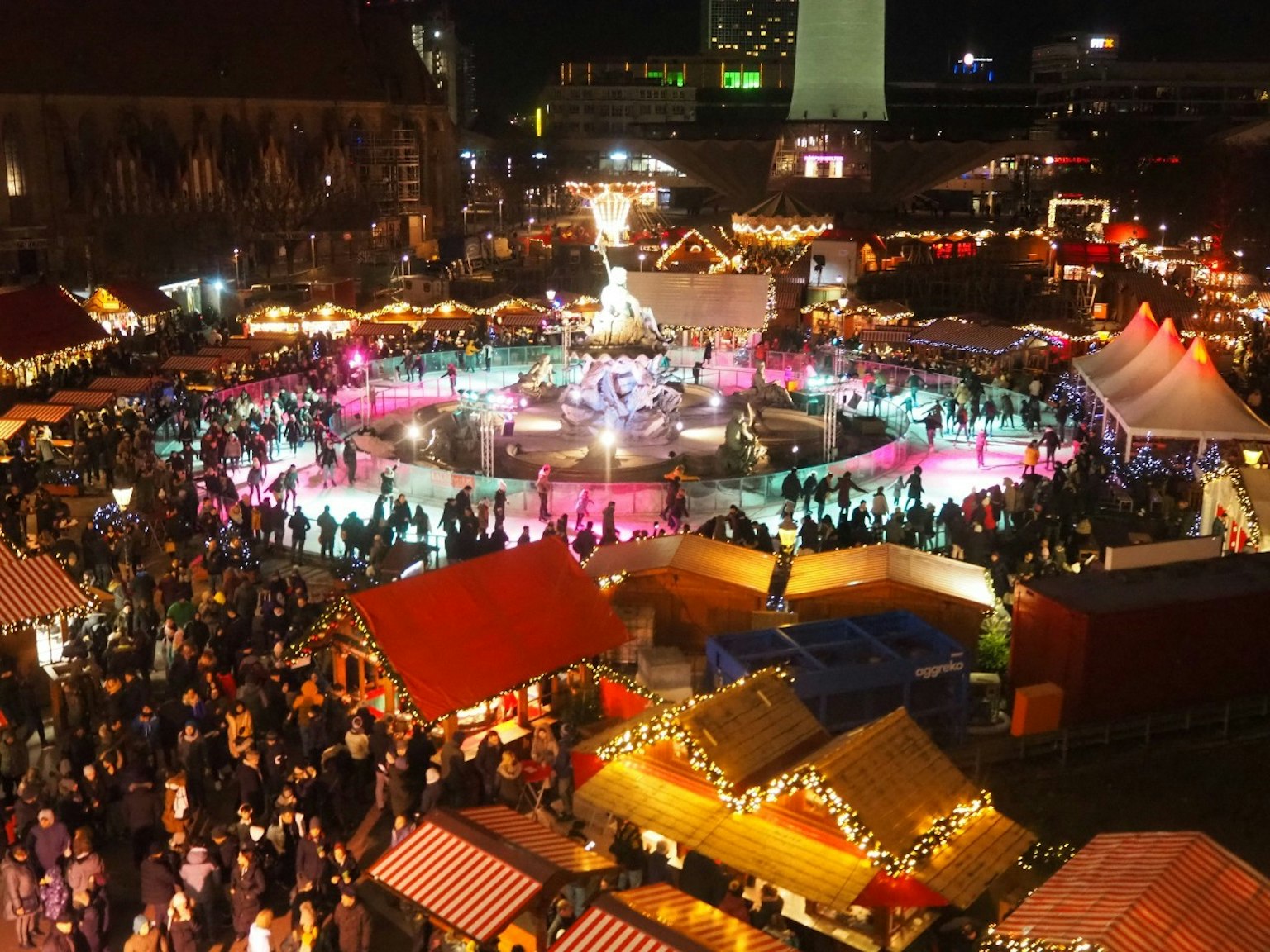 Folla in un vivace mercatino di Natale con bancarelle colorate di notte