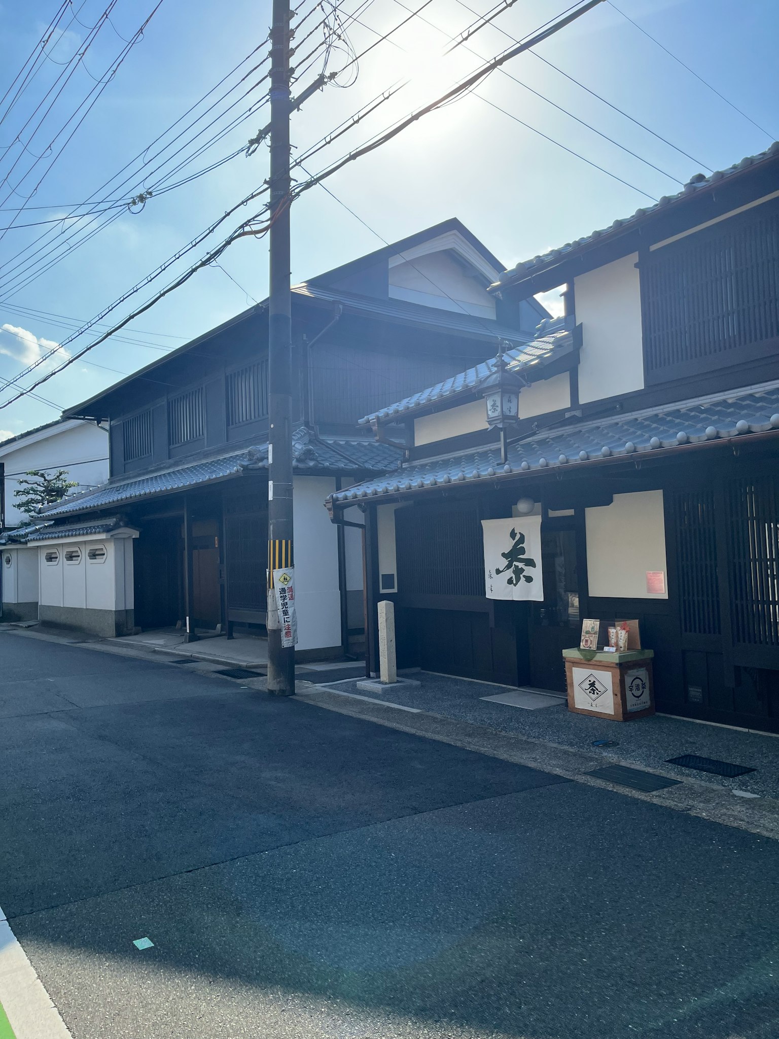 街道上排列着传统的黑色日本房屋，蓝天和阳光明媚