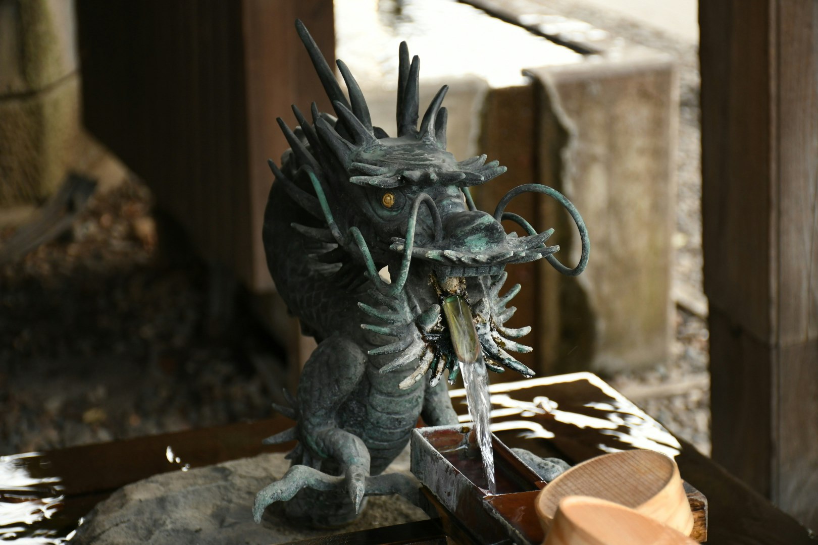 dragon statue figurine placed against a stone wall in an alley
