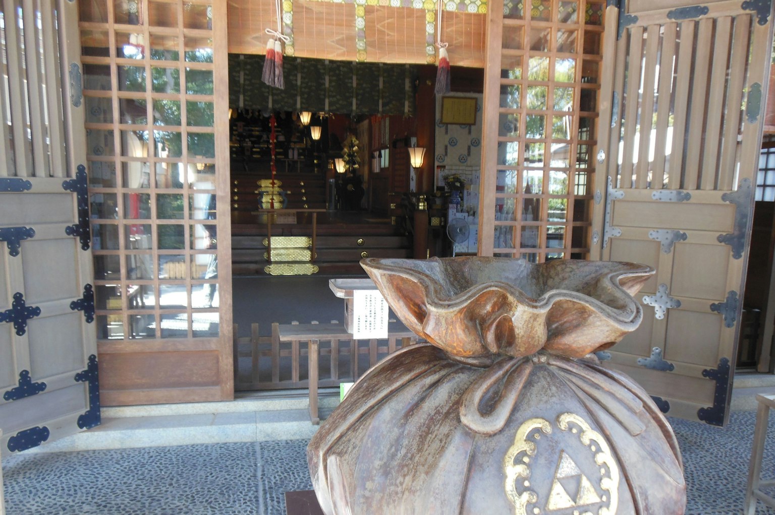 Große Holztasche am Eingang mit traditioneller japanischer Gebäudetür im Hintergrund
