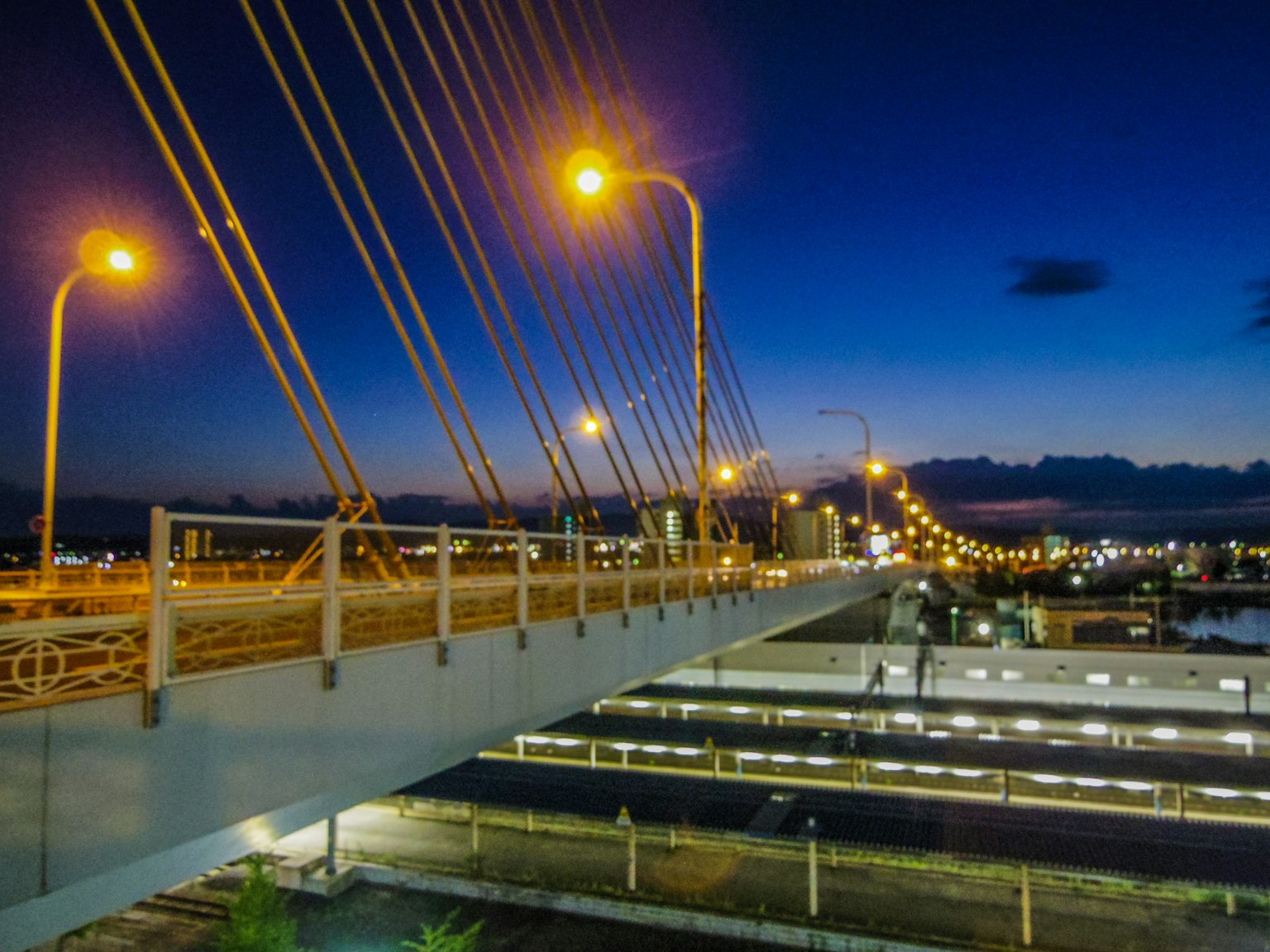 ทิวทัศน์ยามค่ำคืนของสะพานเคเบิลที่มีไฟถนนสว่าง