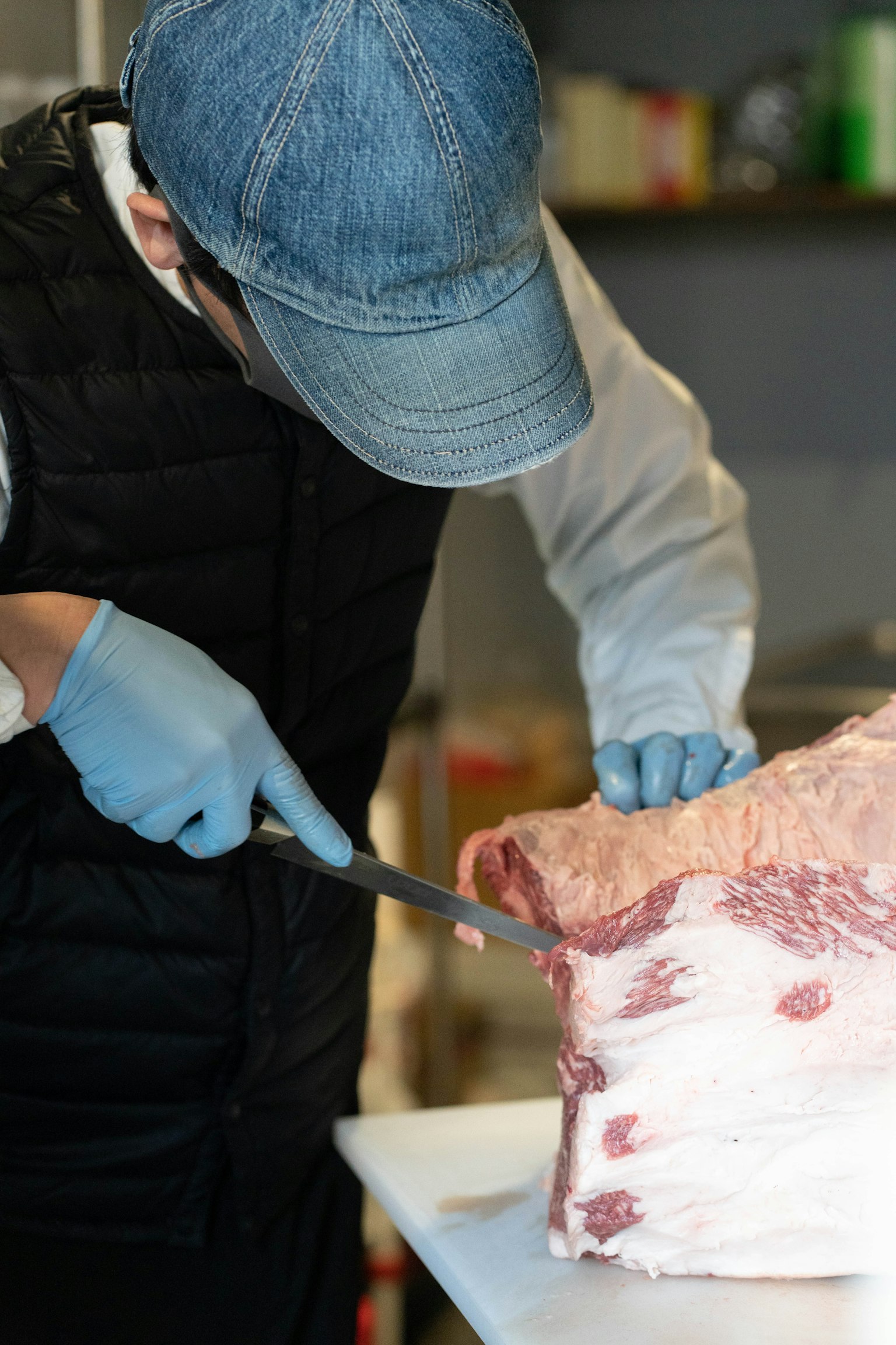Persona cortando carne en un entorno de cocina
