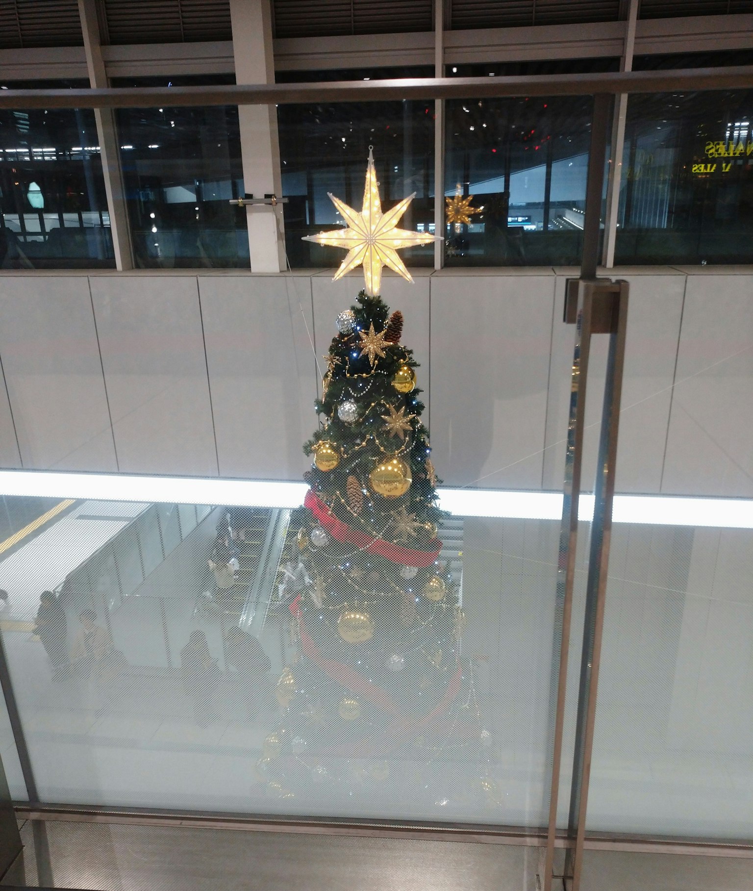 空港のクリスマスツリーが金色の星で飾られている