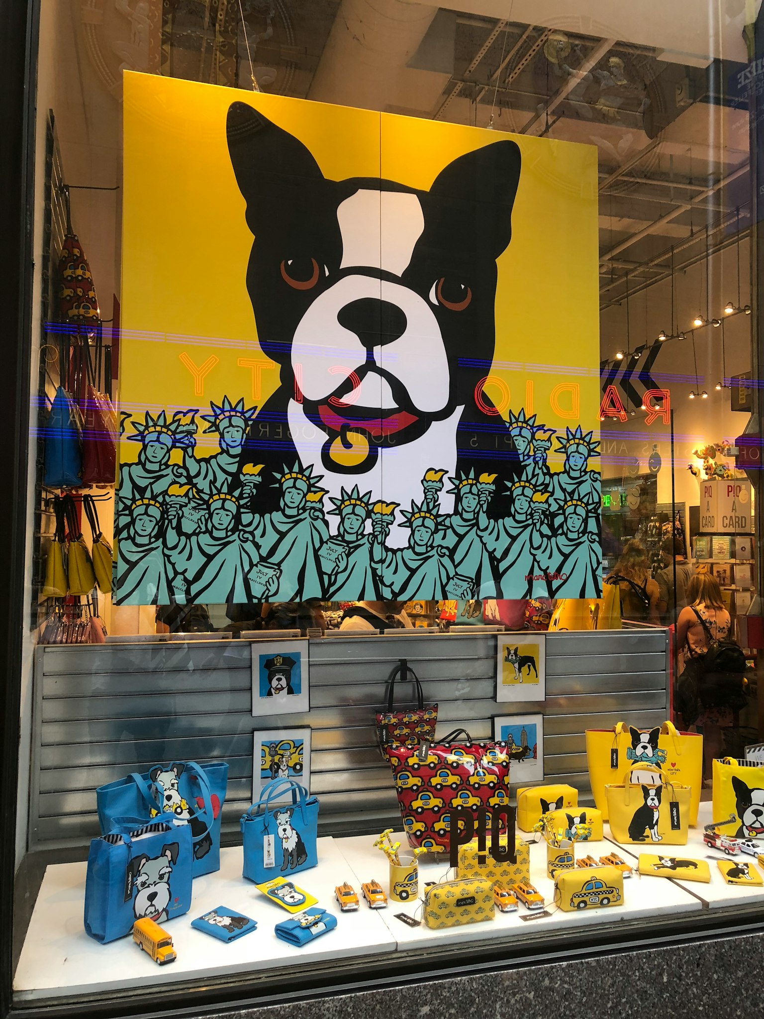 Exhibición de ventana con gran arte de Boston Terrier sobre fondo amarillo y mercancía colorida abajo