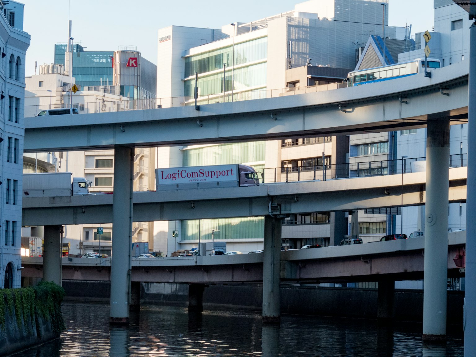 Stadtlandschaft mit erhöhter Autobahn und Wasserstraße