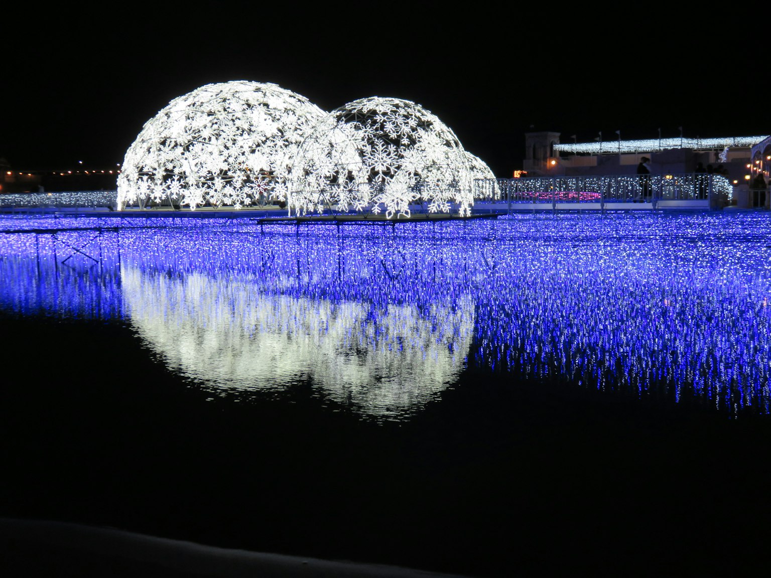 โดมสีขาวสวยงามลอยอยู่บนทะเลสาบในตอนกลางคืนพร้อมกับการสะท้อนแสงสีฟ้า