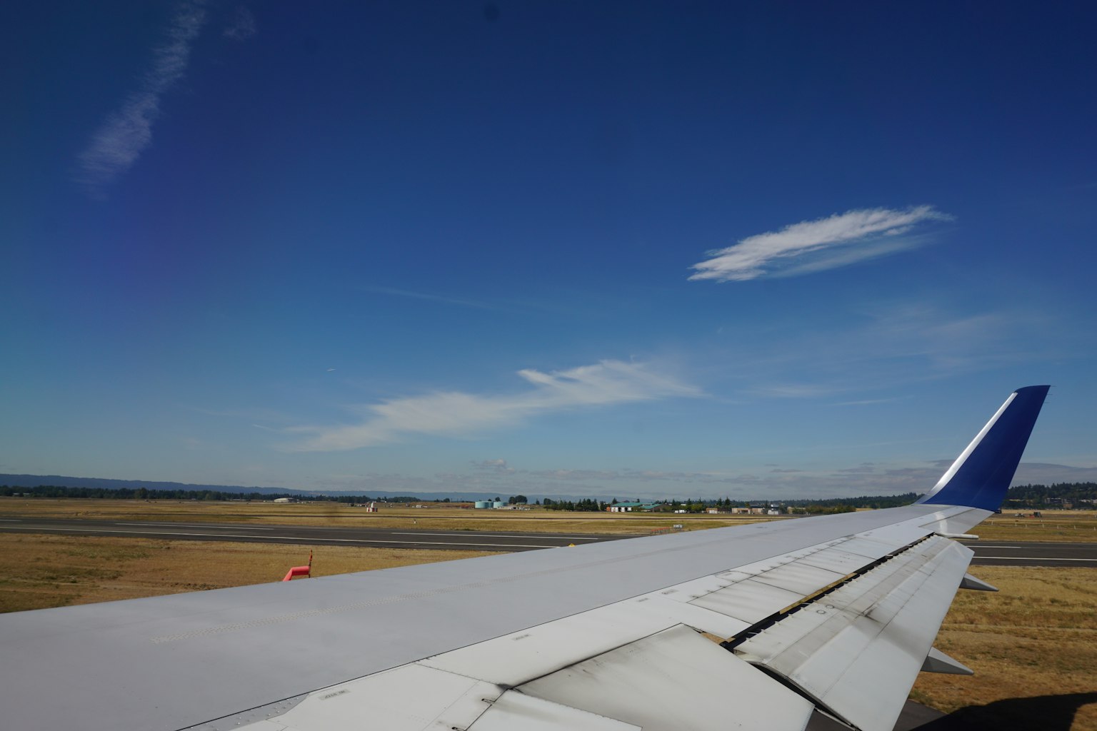View of an airplane wing against a clear blue sky