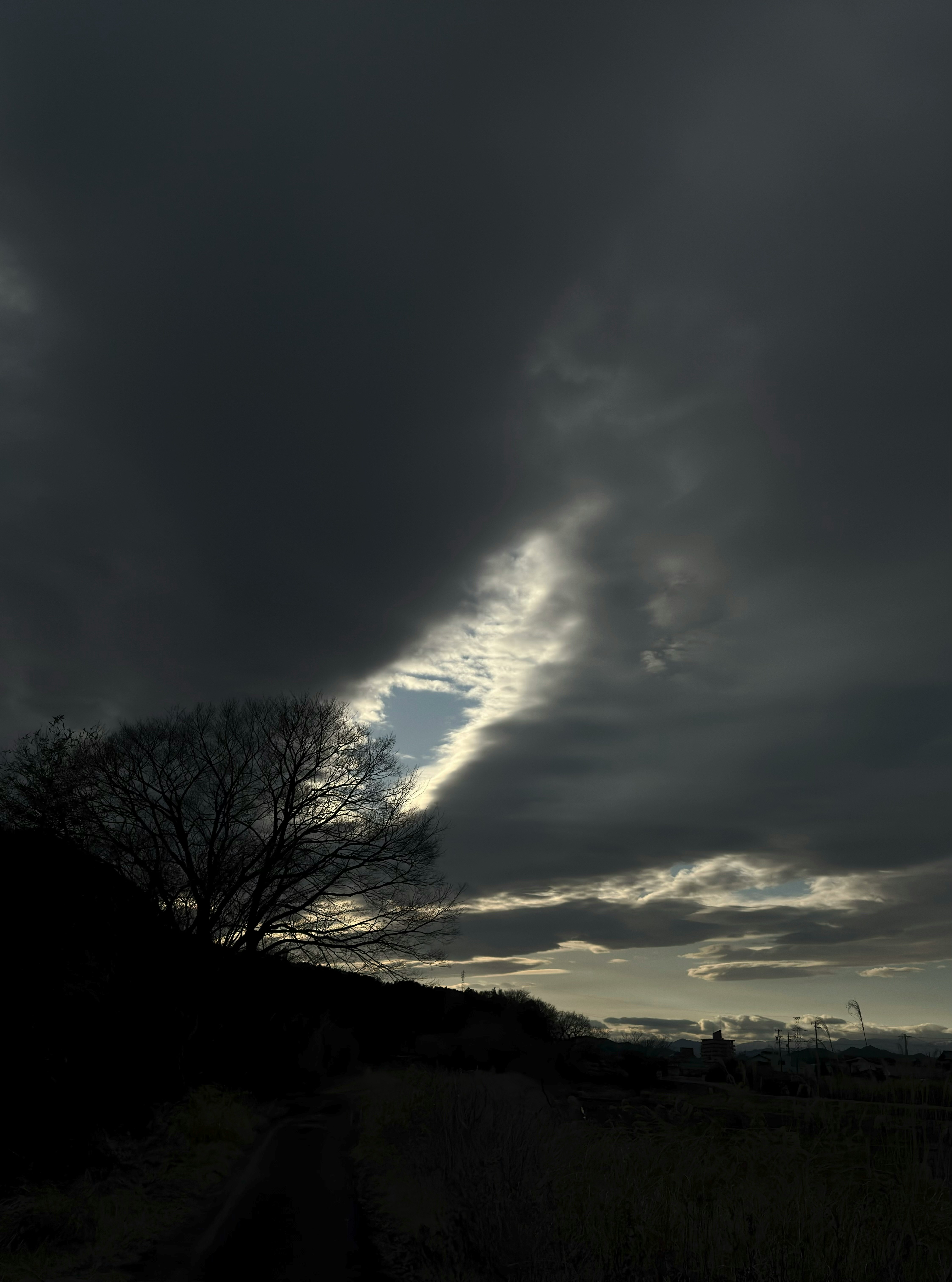 Winter-Dämmerung am Himmel mit dichten Wolken und hoffnungsvollem blauem Aufriss
