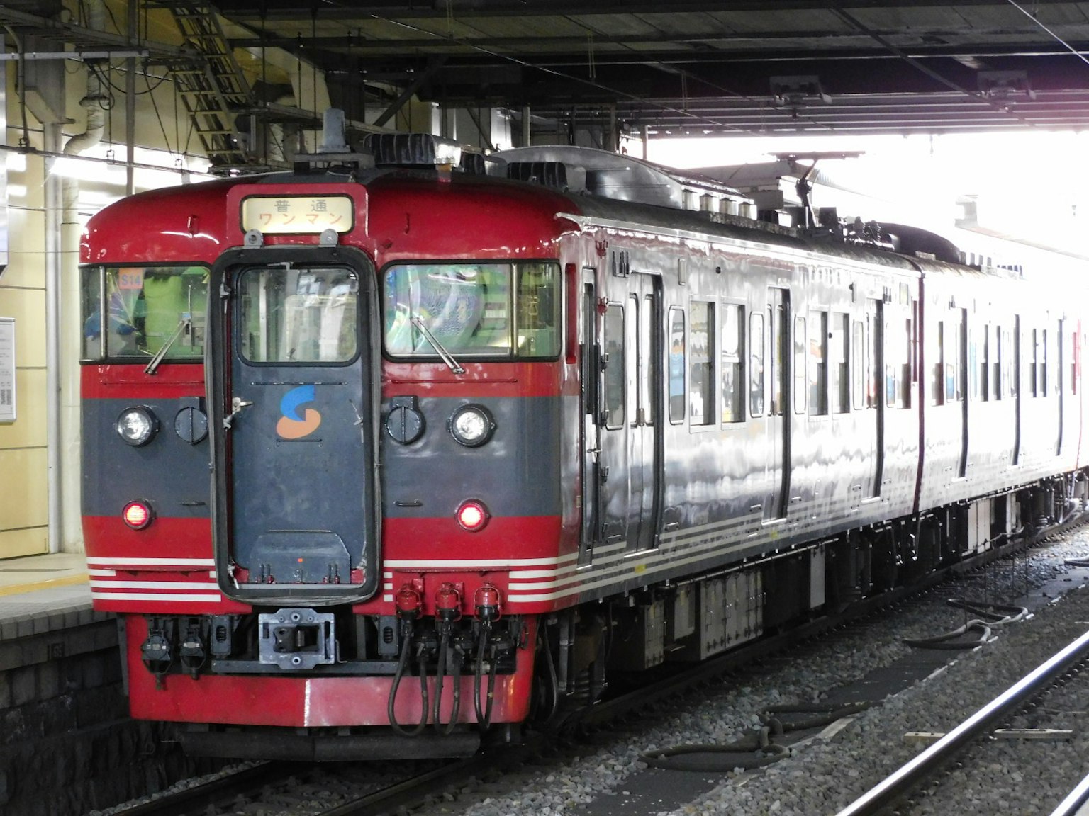 รถไฟสีแดงและสีเงินจอดอยู่ที่ชานชาลา
