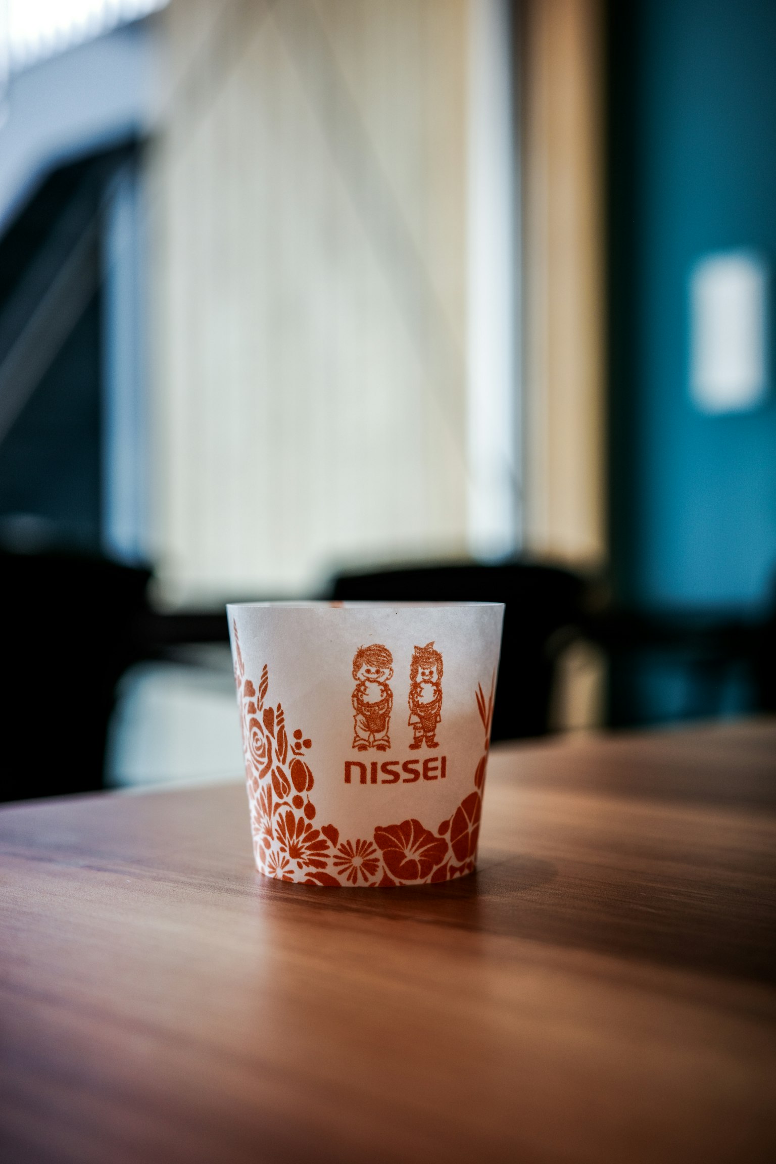 白色杯子上有红色花卉设计和'nissai'字样