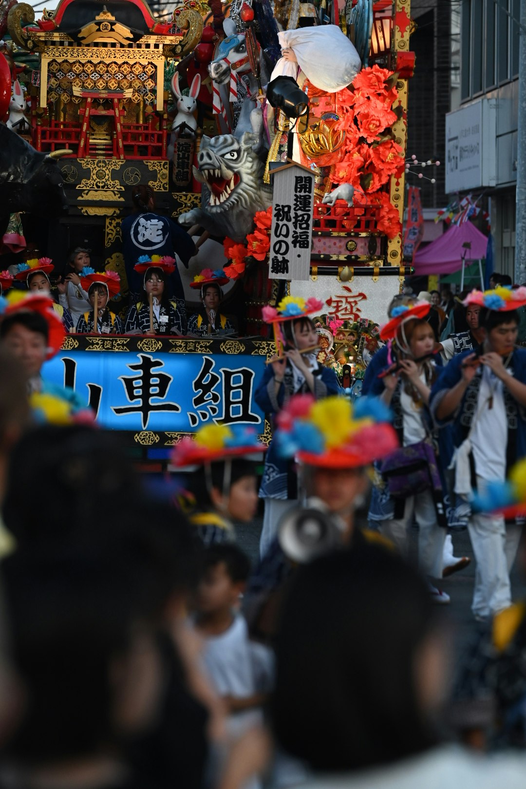 祭りの山車と提灯が並ぶにぎやかな通りの群衆