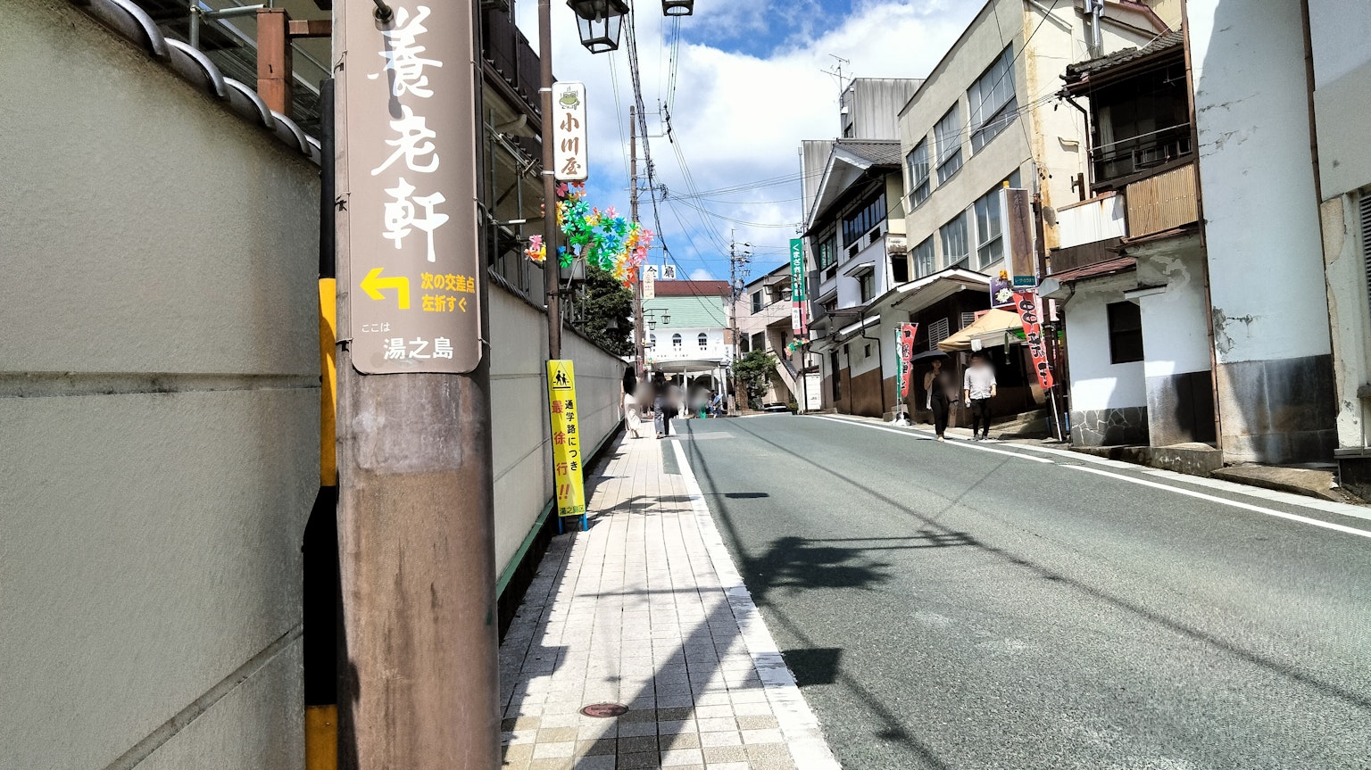 Quiet street scene with shops under a blue sky and sunlight