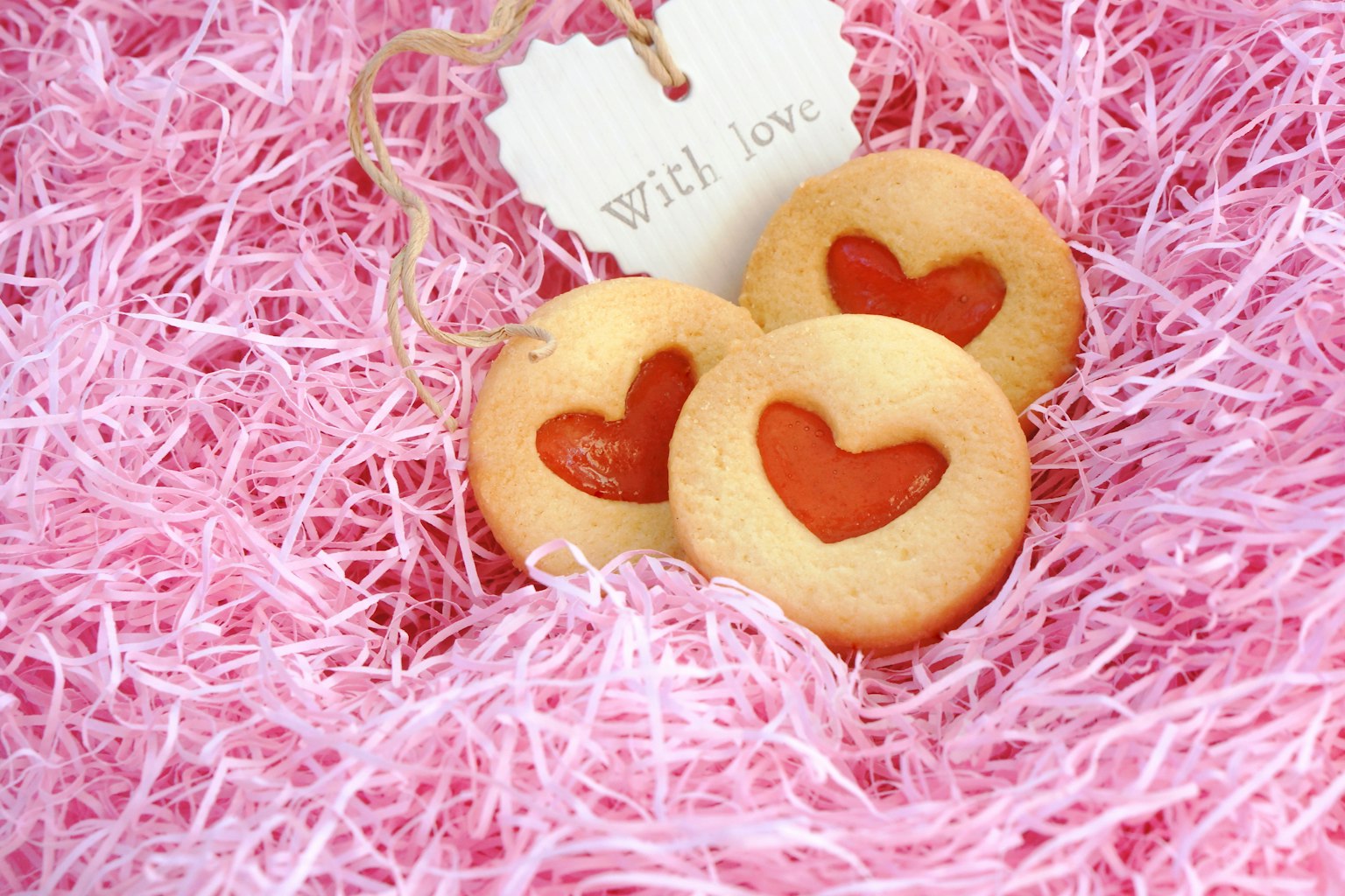 Biscotti a forma di cuore su un letto di paglia rosa