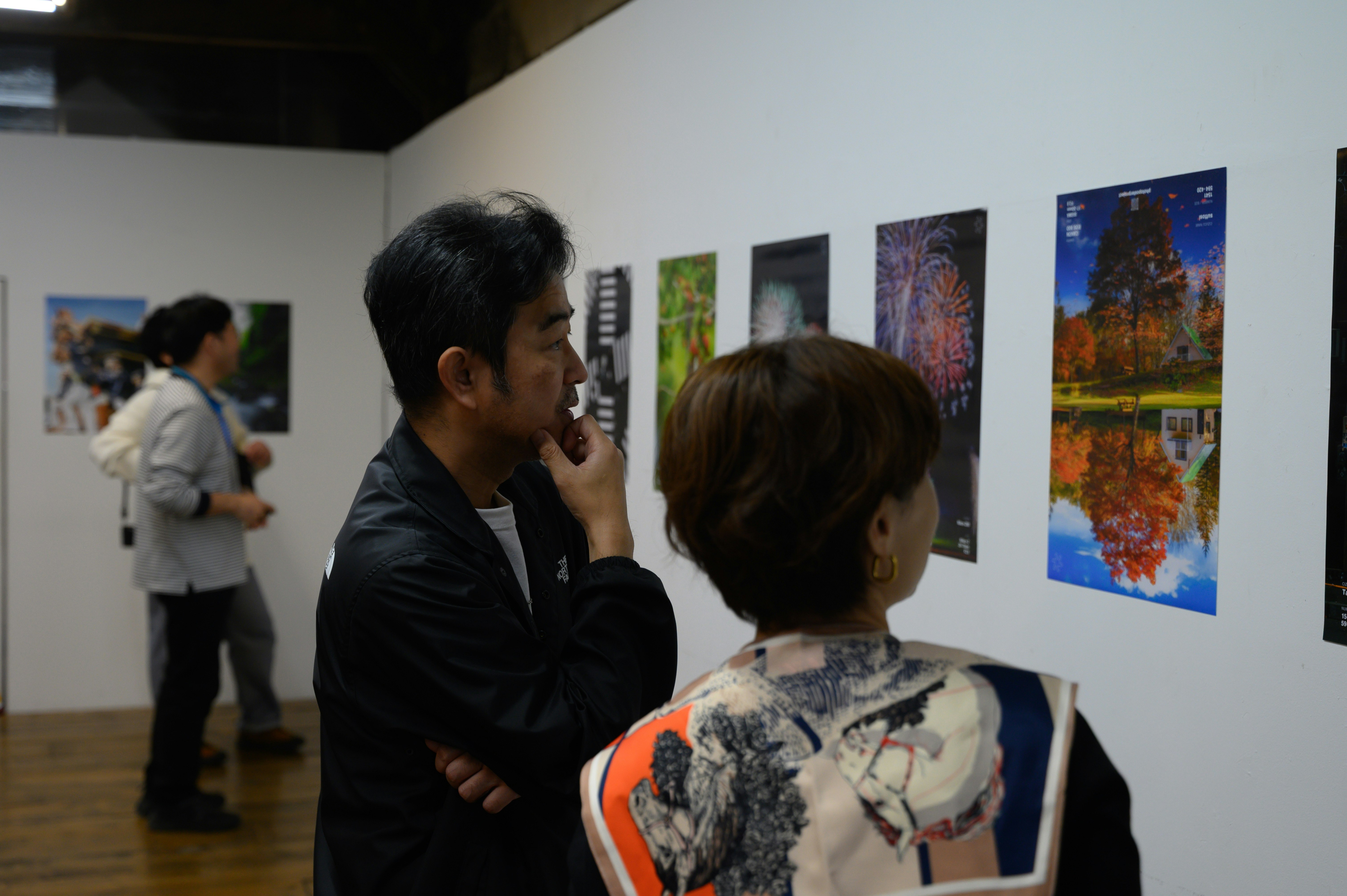 展示会場で絵画ポスターを見つめる親子