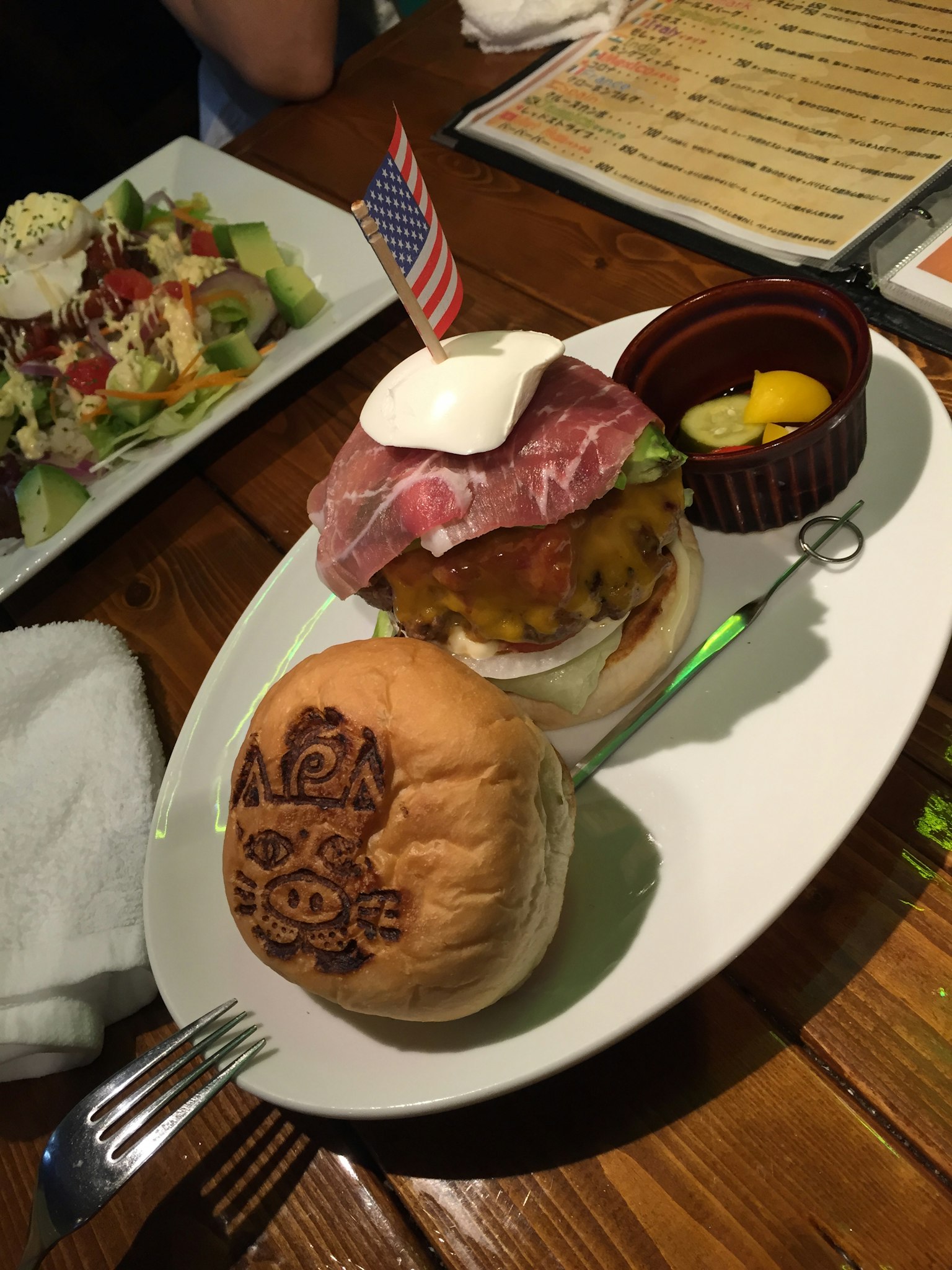 Un hamburger garni de jambon et de fromage un drapeau américain est planté dessus