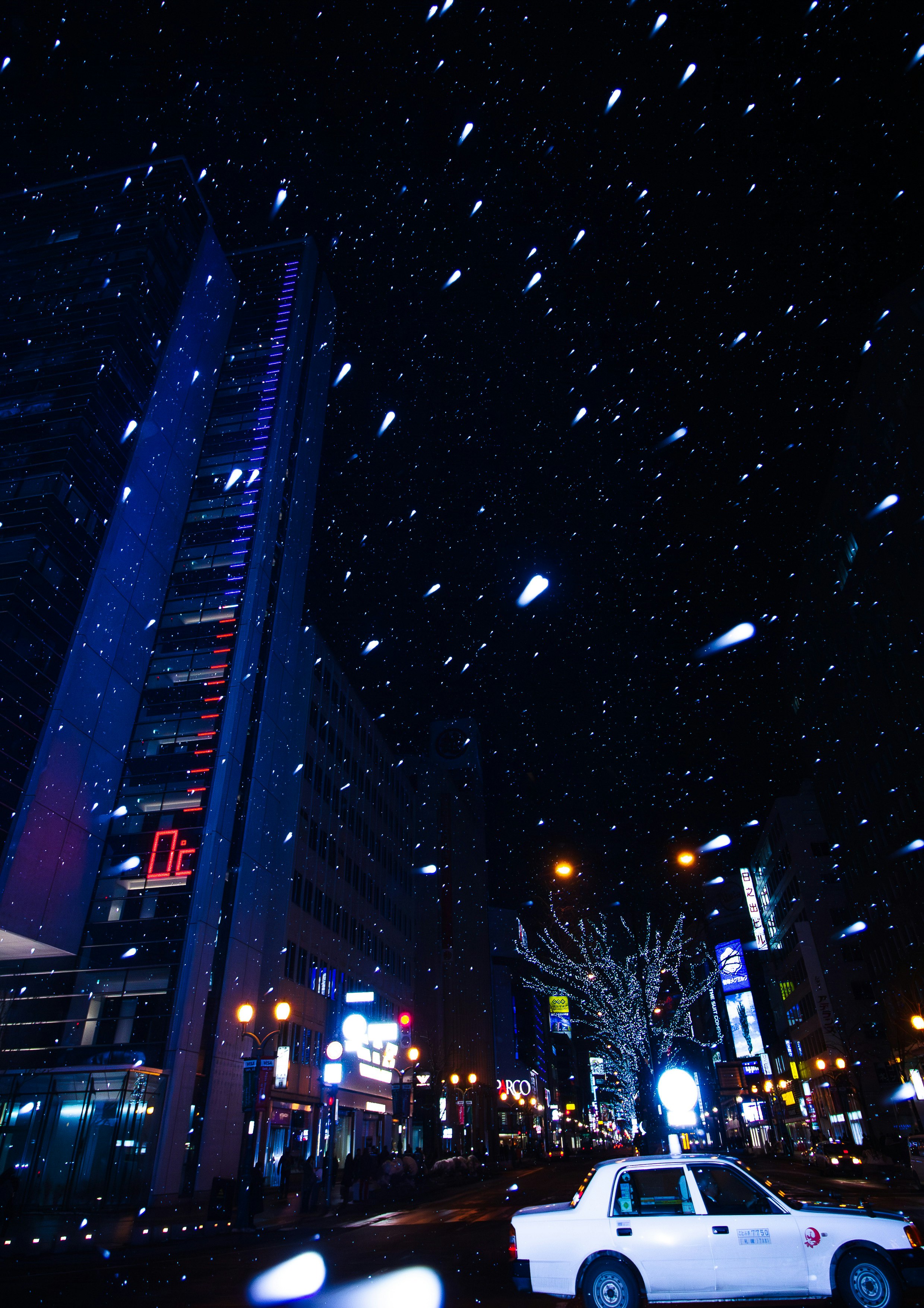 Neonbeleuchtete Nachtstraße mit fallendem Schnee und vorbeifahrendem Auto