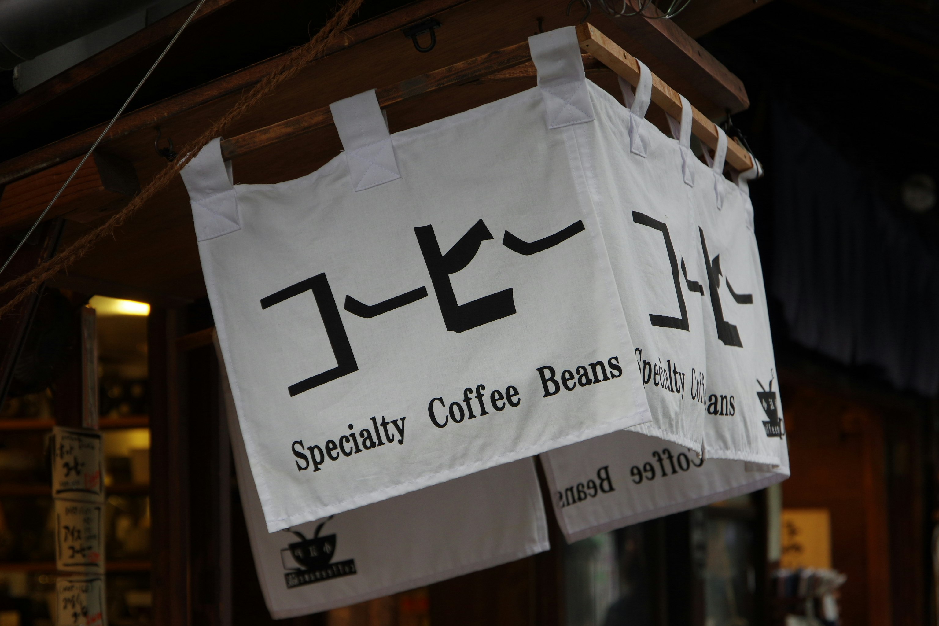店内に下がるコーヒー豆の麻袋と看板