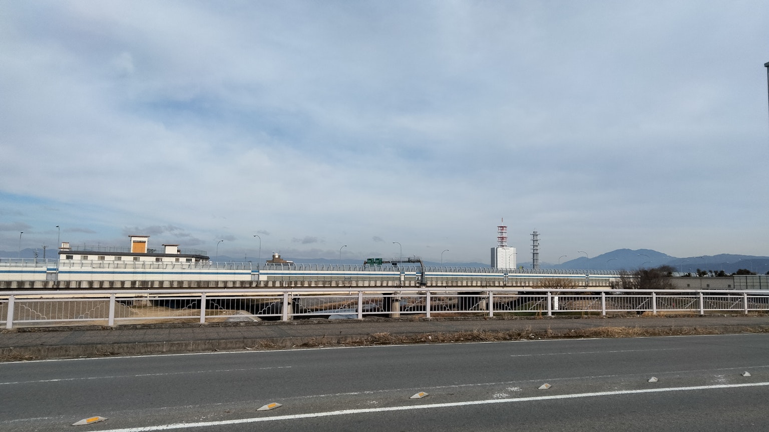Amplio paisaje con una carretera y edificios industriales bajo un cielo nublado