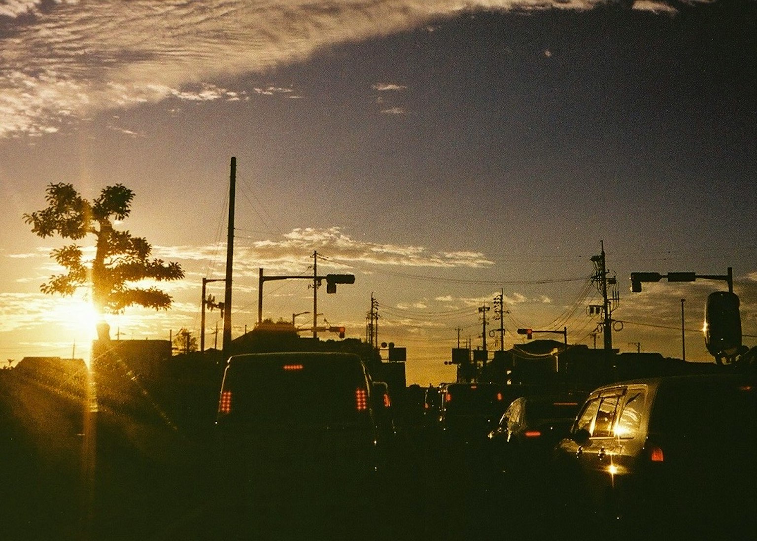 夕日が沈む街の風景 車の列と信号機が見える