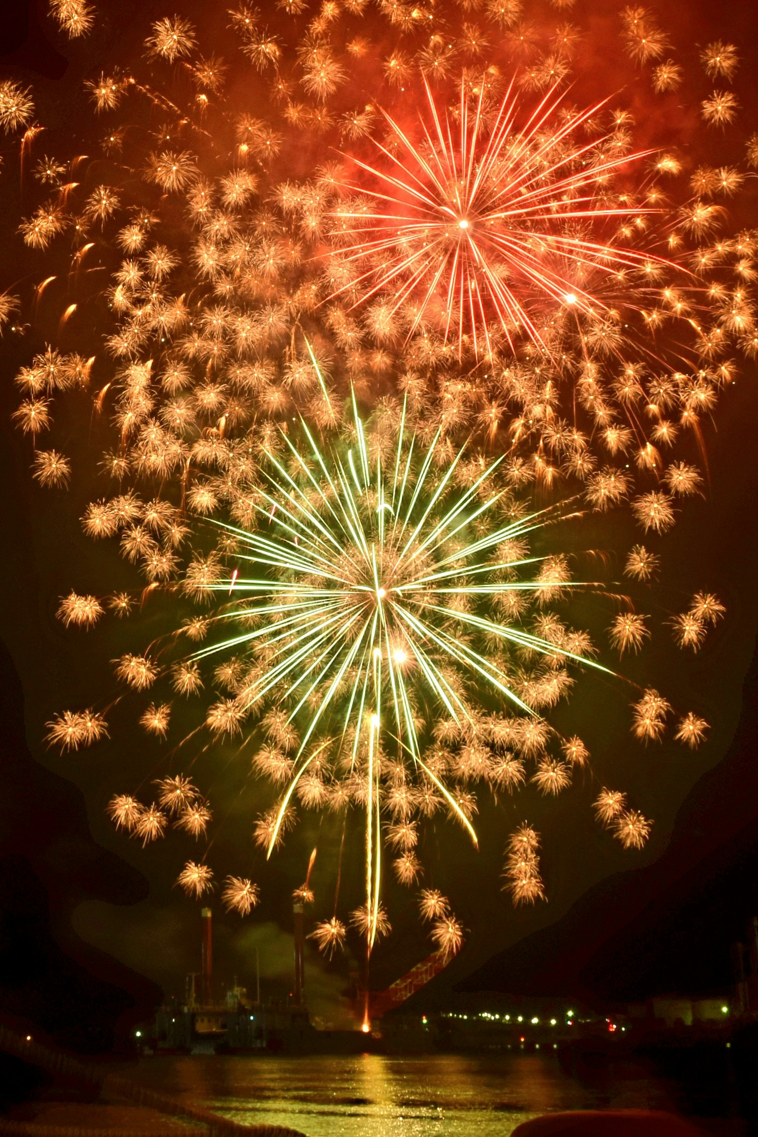 Spettacolo di fuochi d'artificio rossi e verdi nel cielo notturno