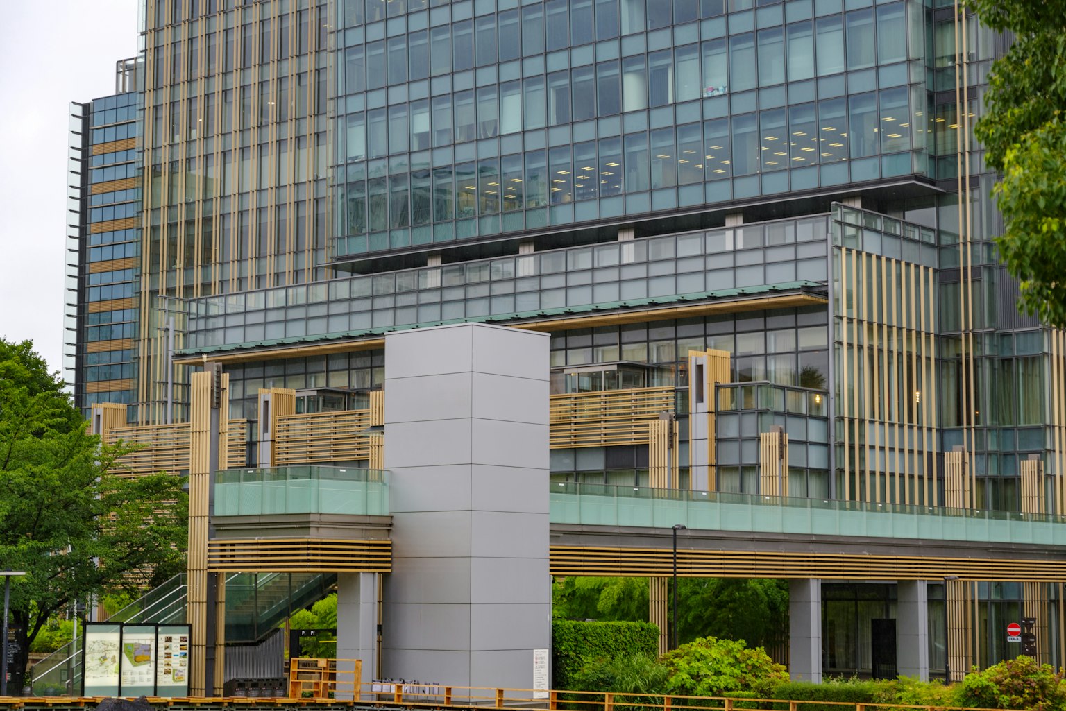 Eksterior gedung perkantoran modern dengan vegetasi subur