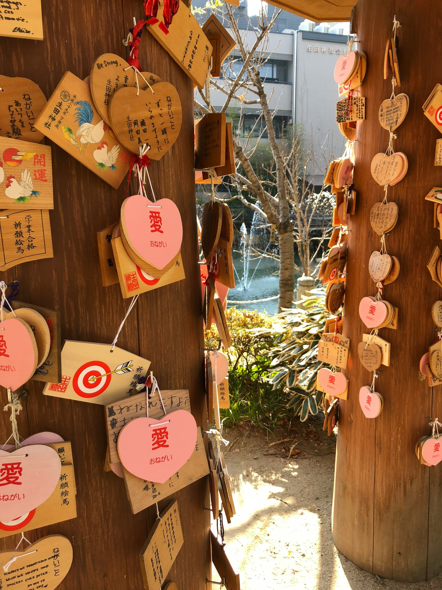 Pilar de madera adornado con placas ema de amor y árboles al fondo