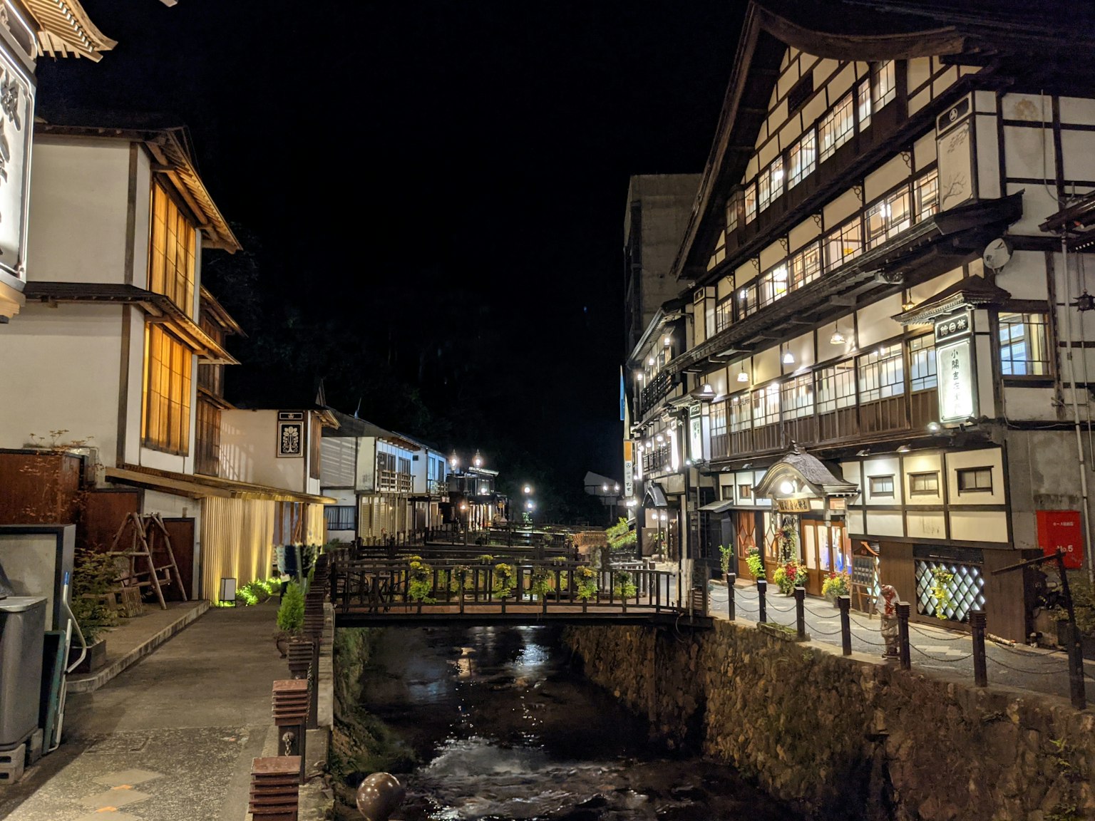 Vista notturna di una città termale con un ponte e edifici tradizionali