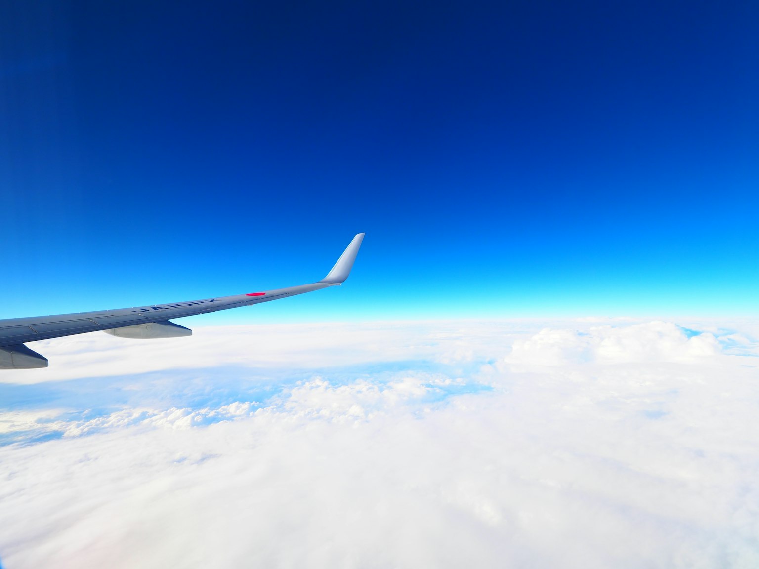 Ala di aereo contro un cielo azzurro chiaro