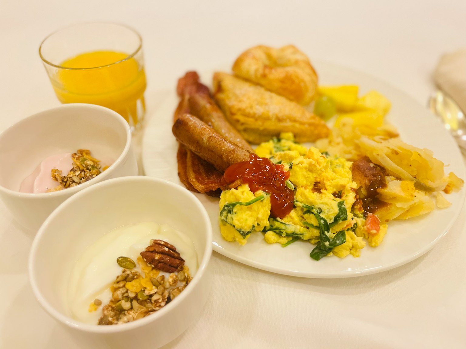 Piatto per colazione con uova strapazzate salsicce e prodotti da forno