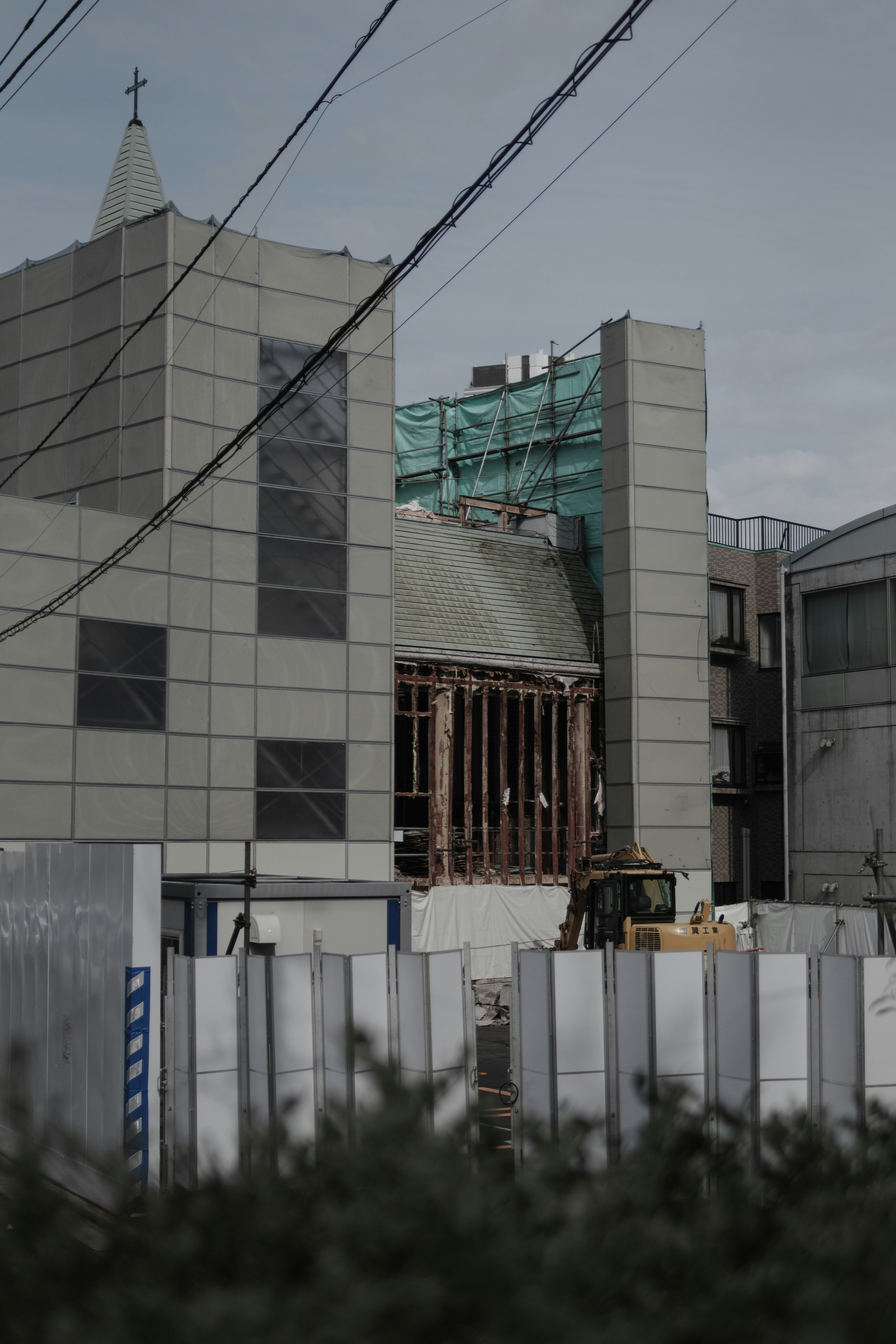 解体工事中の建物と防護フェンスのある都市風景