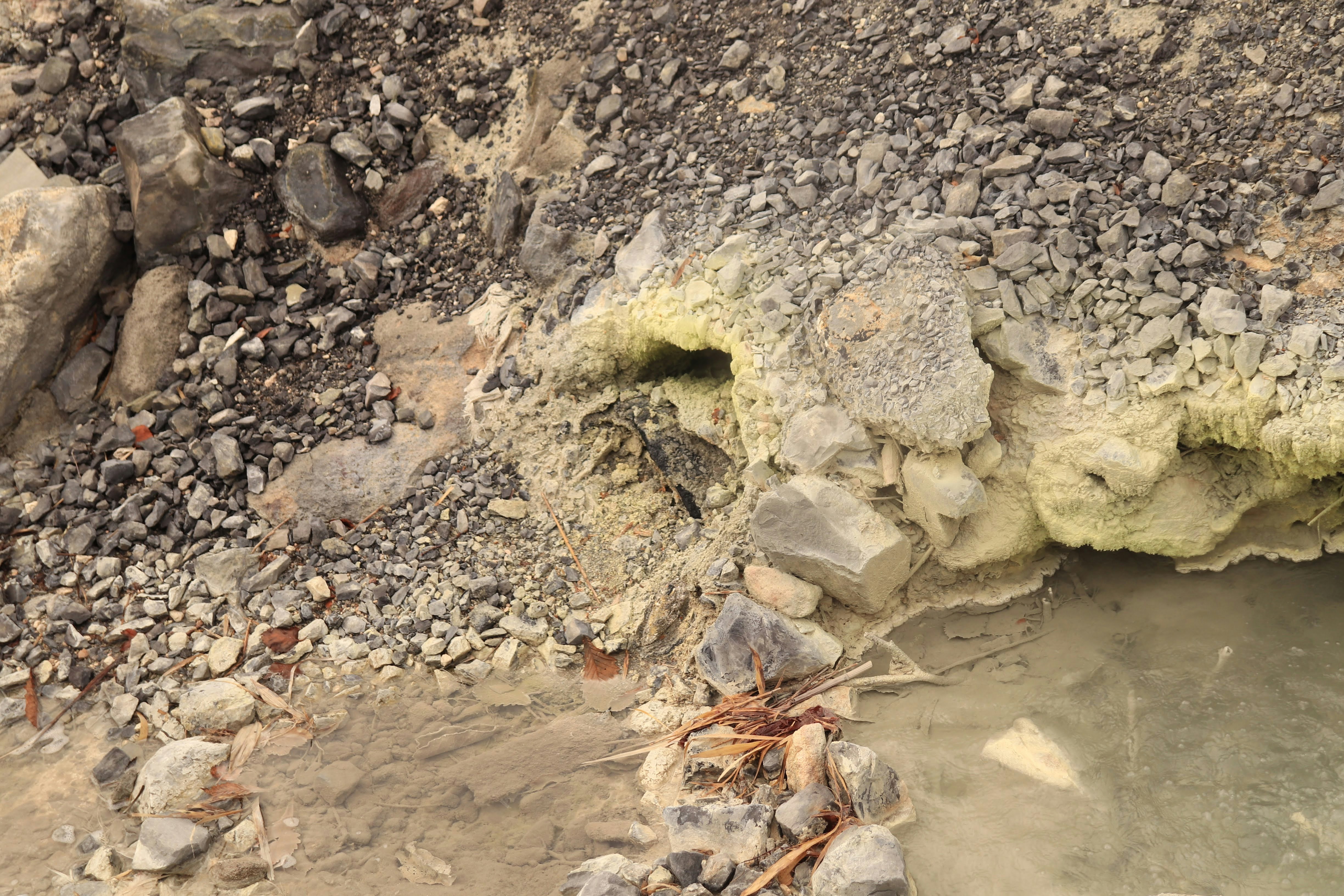 地面の穴の周りに広がる砂利と土