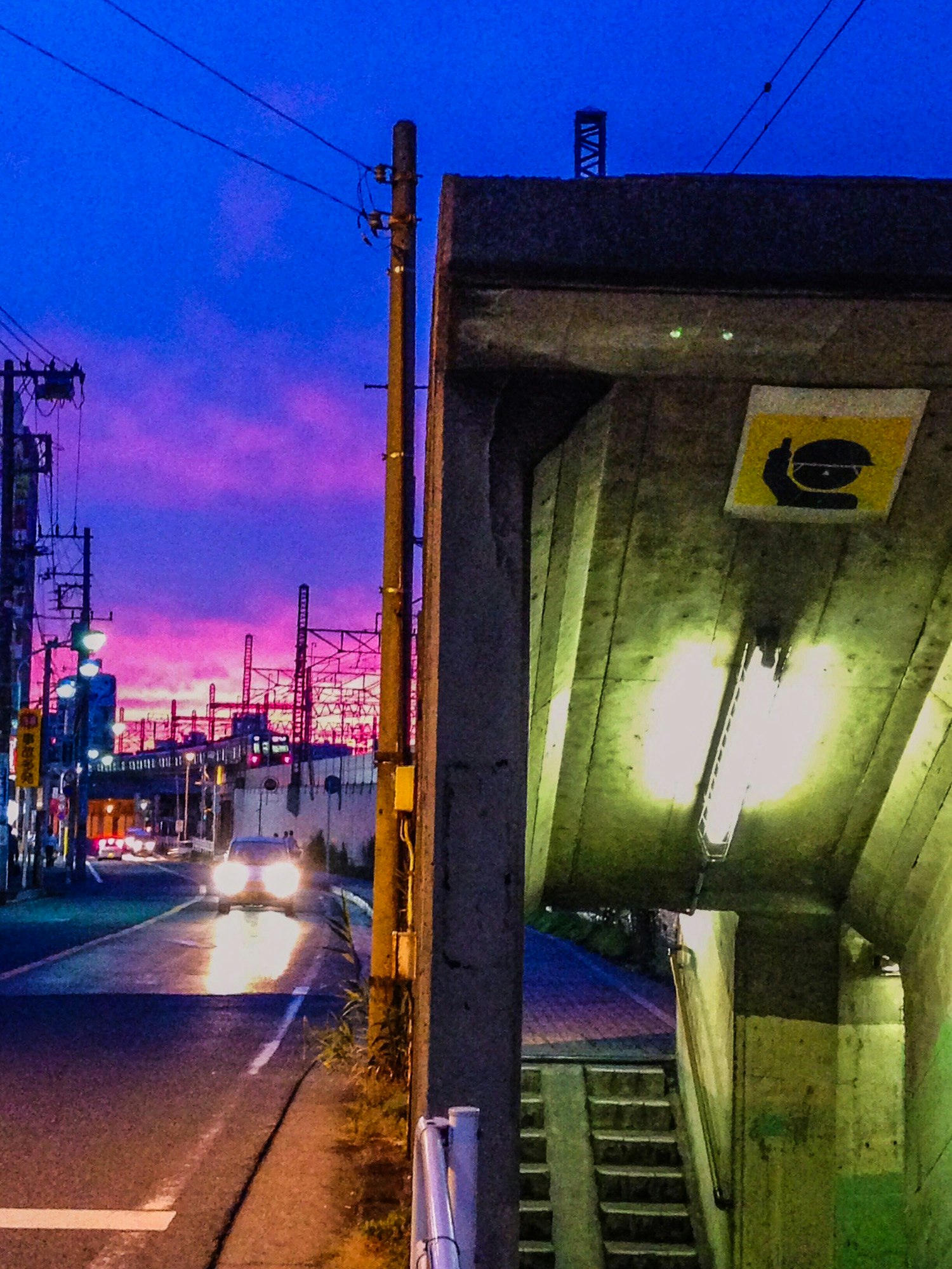 夕暮れの路地で光る街灯と遠景の工業地帯の夜景