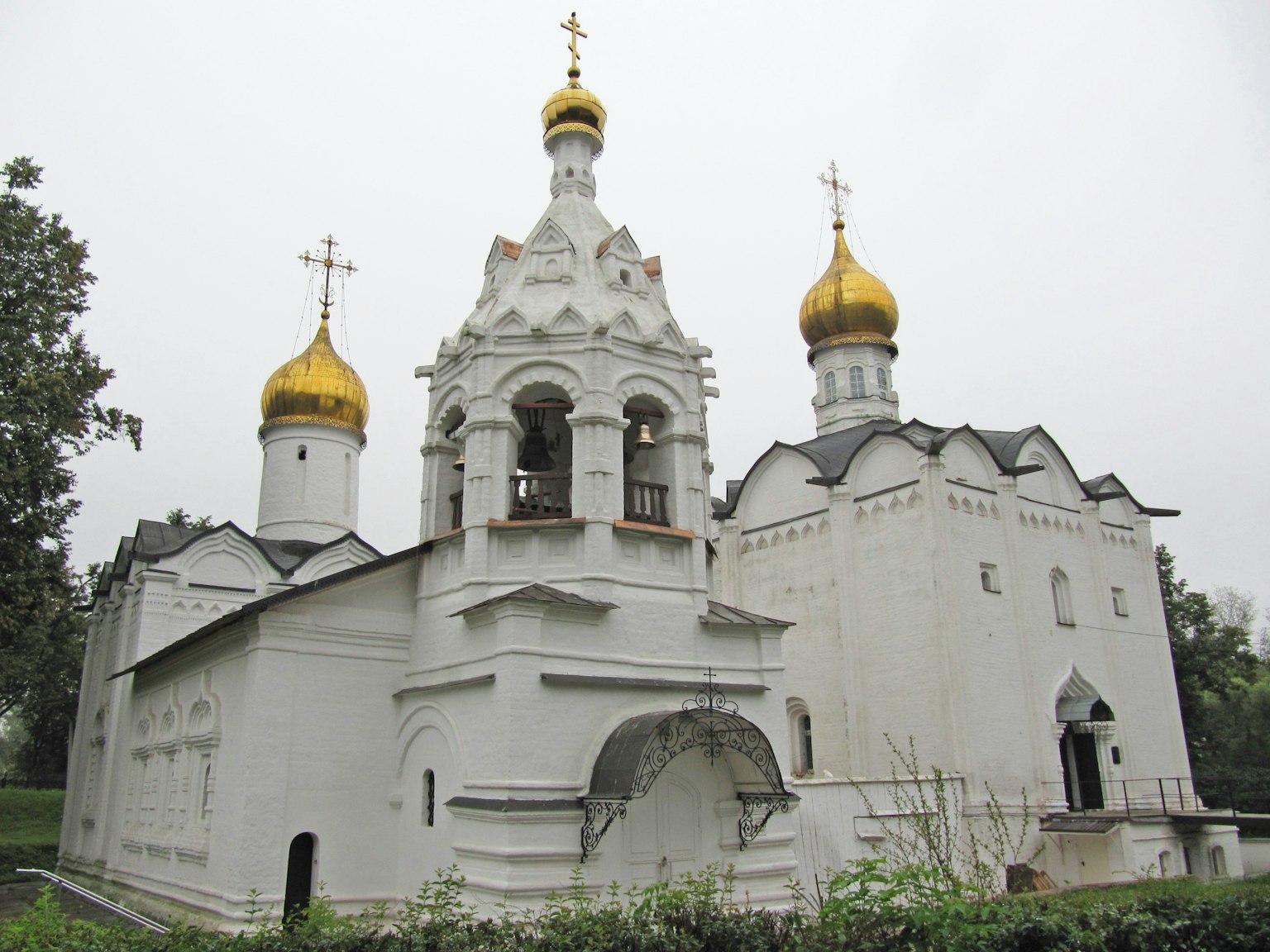 White church featuring golden domes and crosses