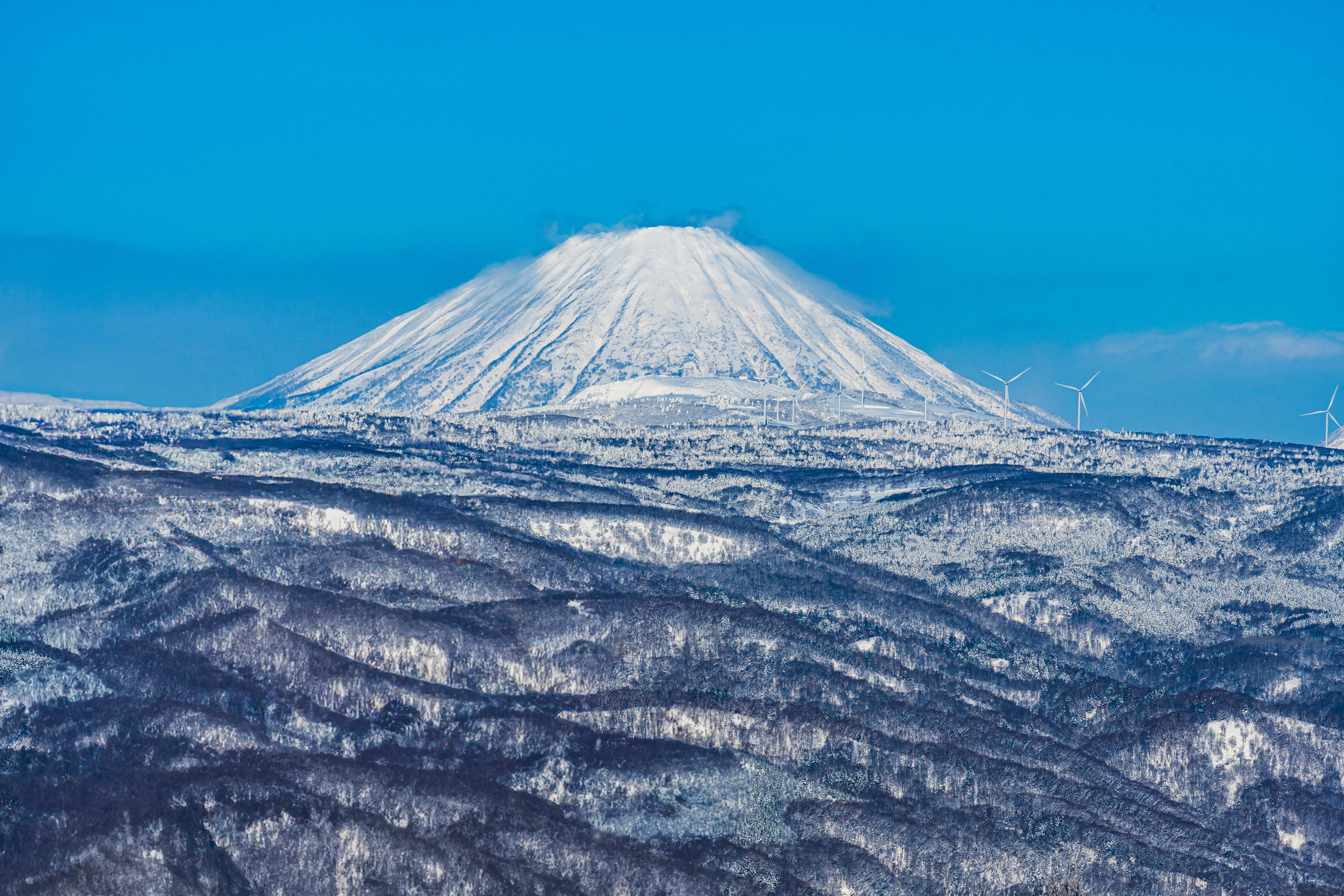 雪化粧した羊蹄山と広がる山並みの景色