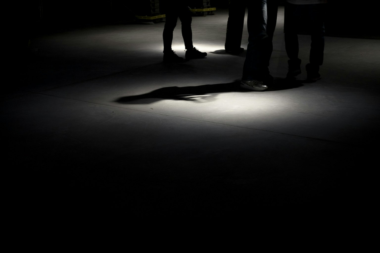 Silhouette di persone in uno spazio scuro illuminate dalla luce