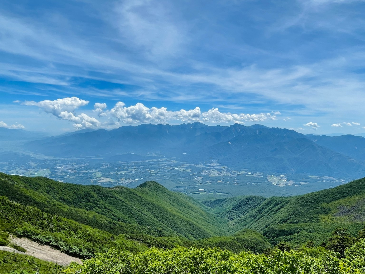 Những ngọn núi xanh tươi dưới bầu trời xanh với những đám mây rải rác