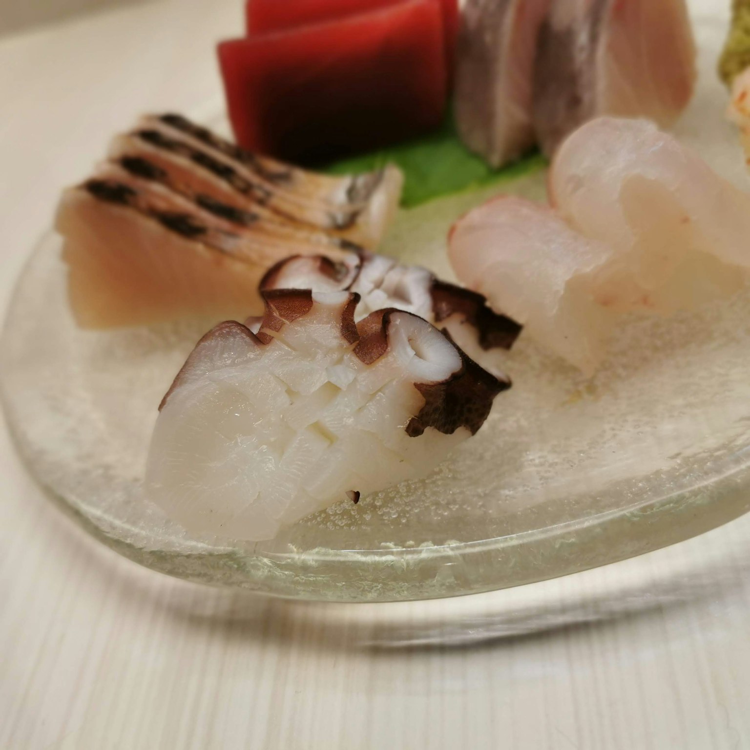 Piring sashimi segar yang disajikan dengan indah termasuk berbagai jenis ikan