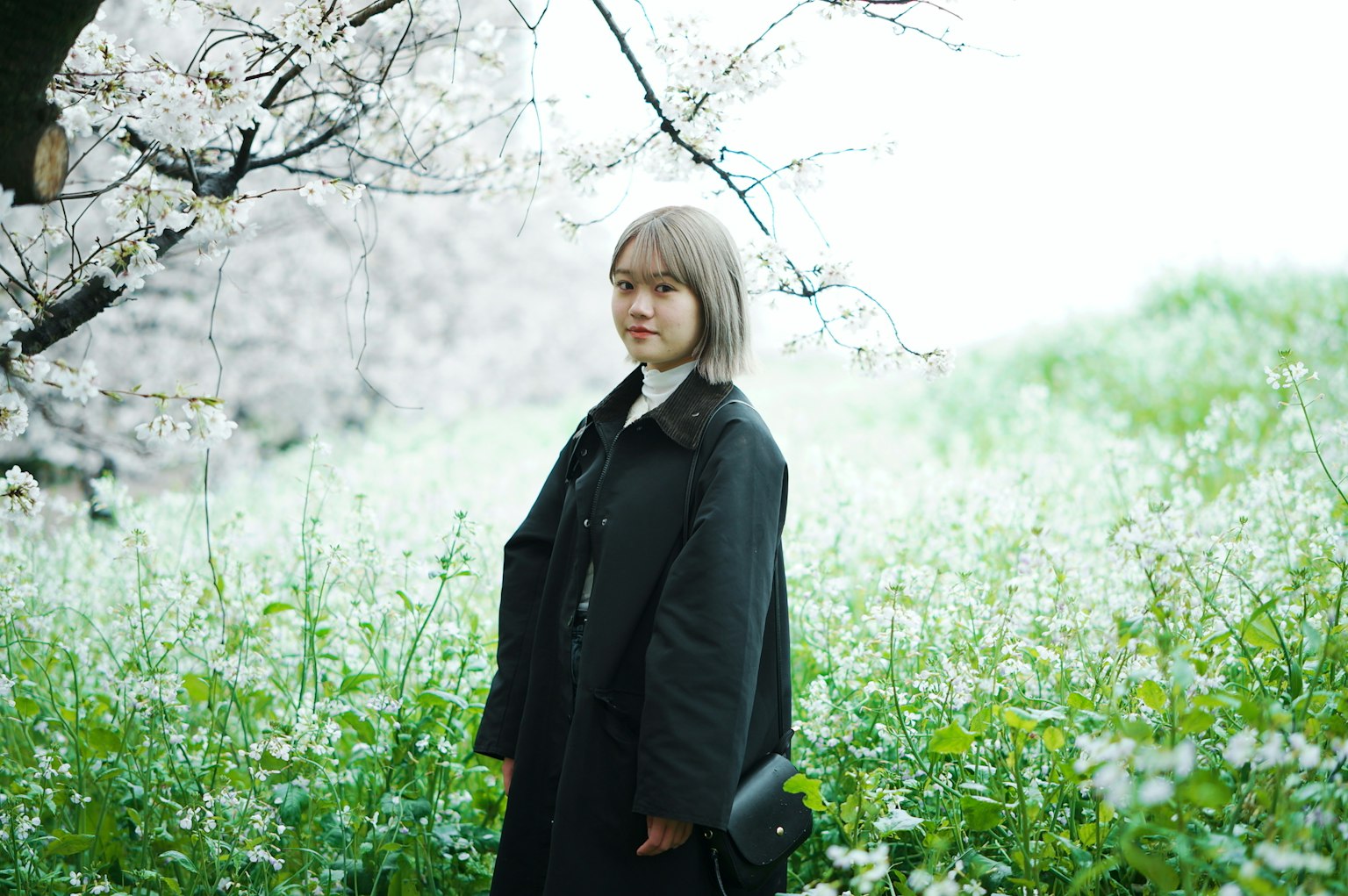 Woman standing in a field of light-colored flowers